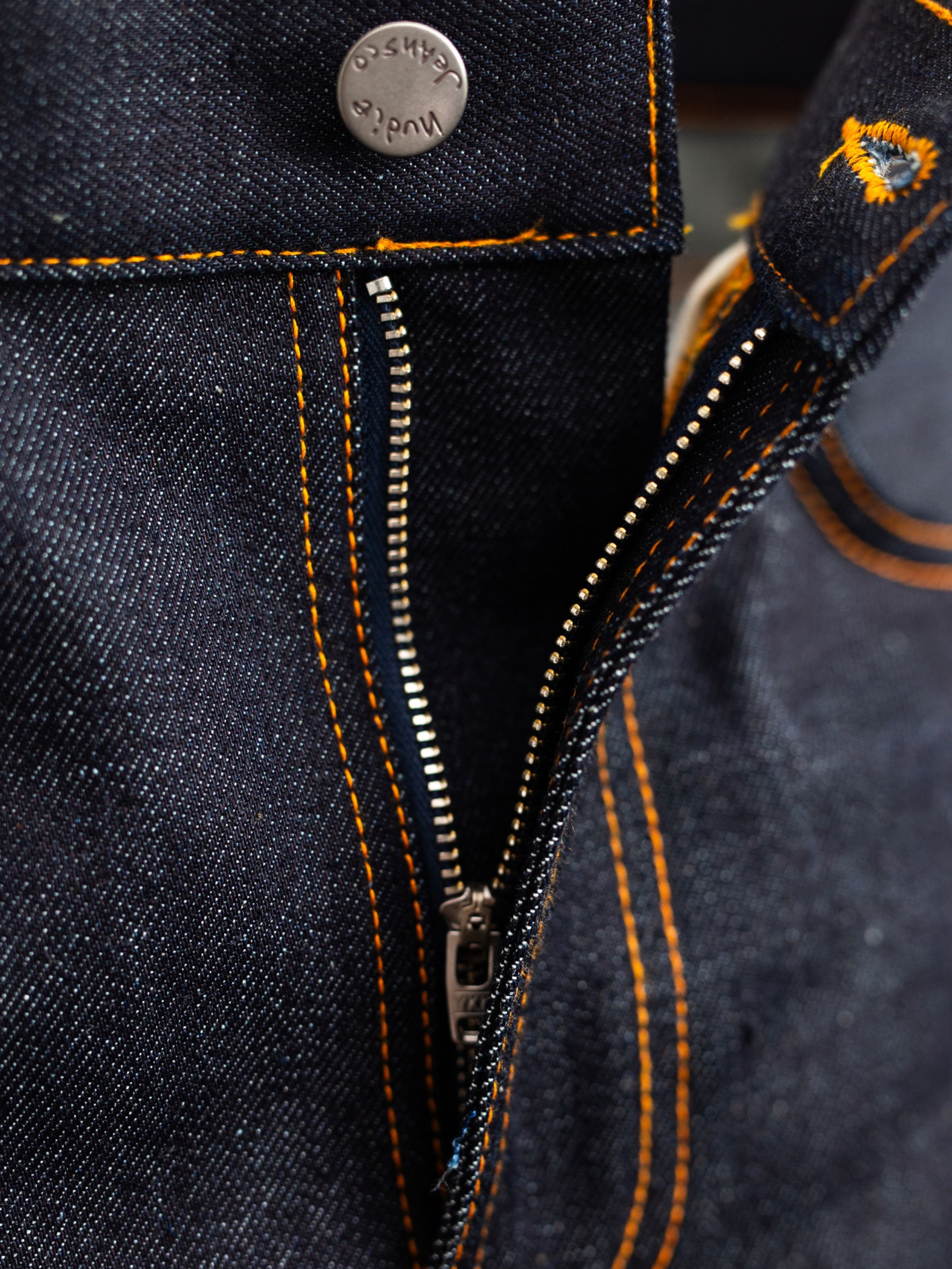 Nudie Jeans Lean Dean Dry Japan Selvage, close-up of the zipper fly and orange stitching details on dark denim.