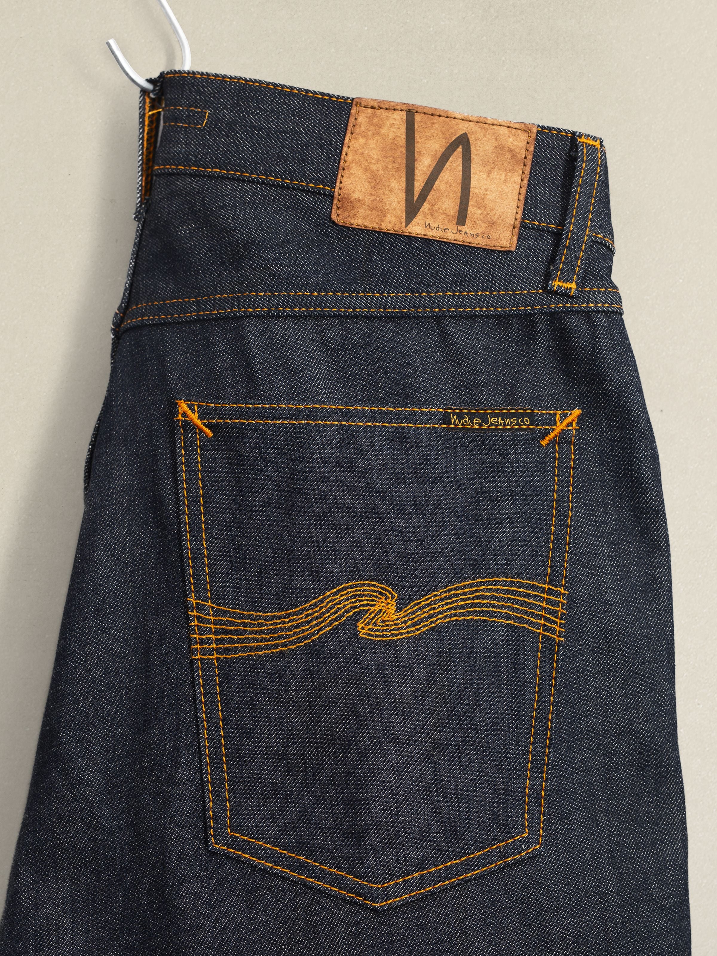 Steady Eddie II Dry Selvedge jeans, close-up of back pocket, jacron patch, and orange seams.