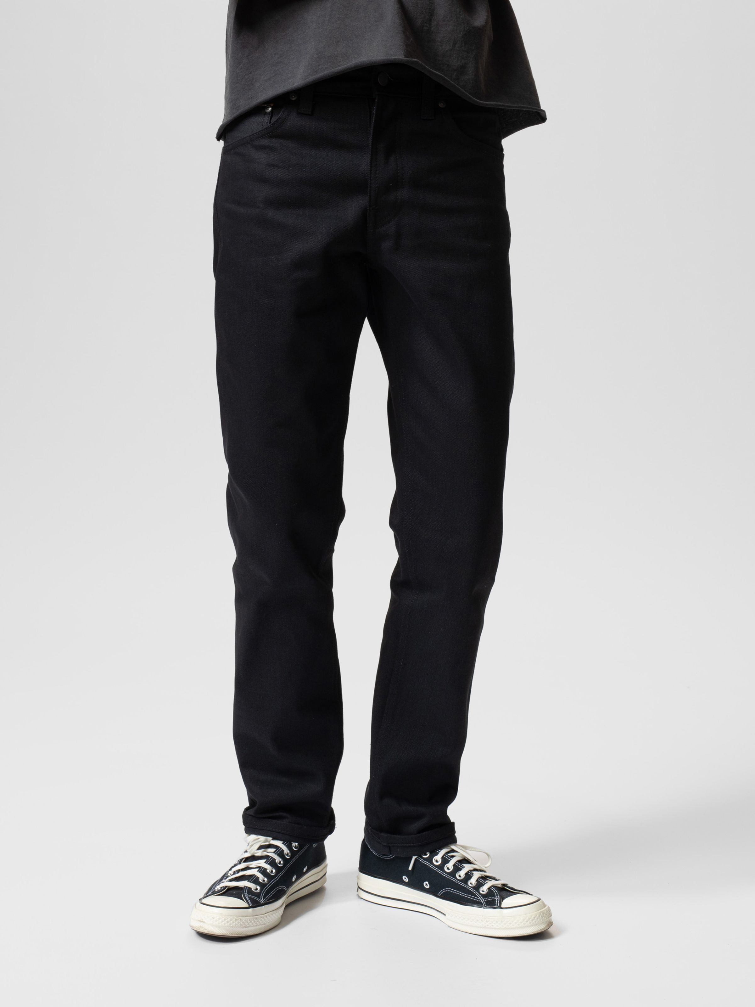 Nudie Jeans Steady Eddie II in Dry Black Selvage, men's regular tapered fit jeans shown full length on a model.