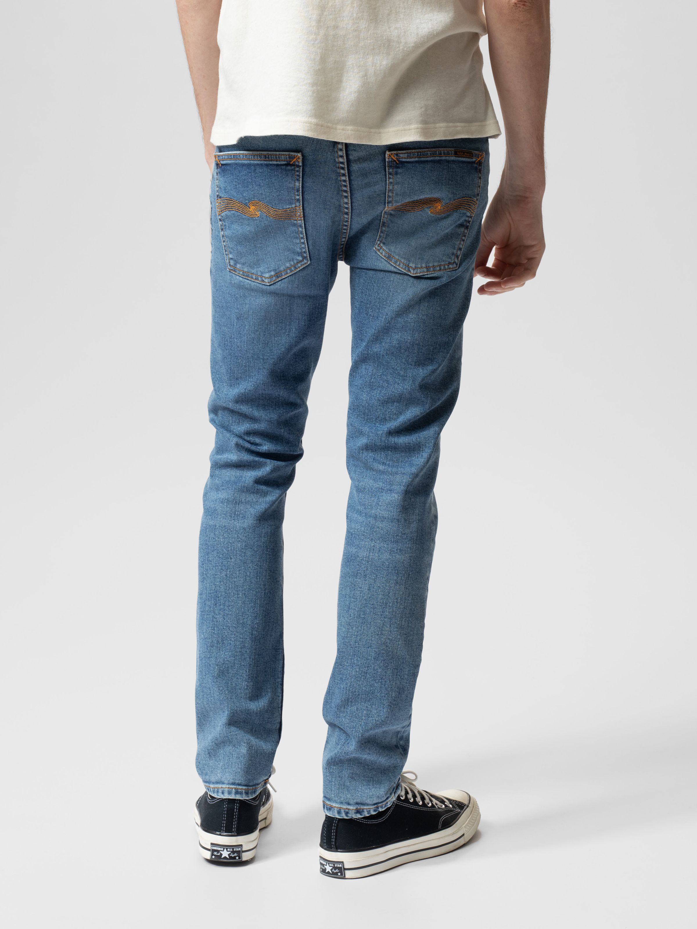Nudie Jeans Lean Dean in Lost Orange, men's slim tapered fit jeans shown from behind on a model against a white background.