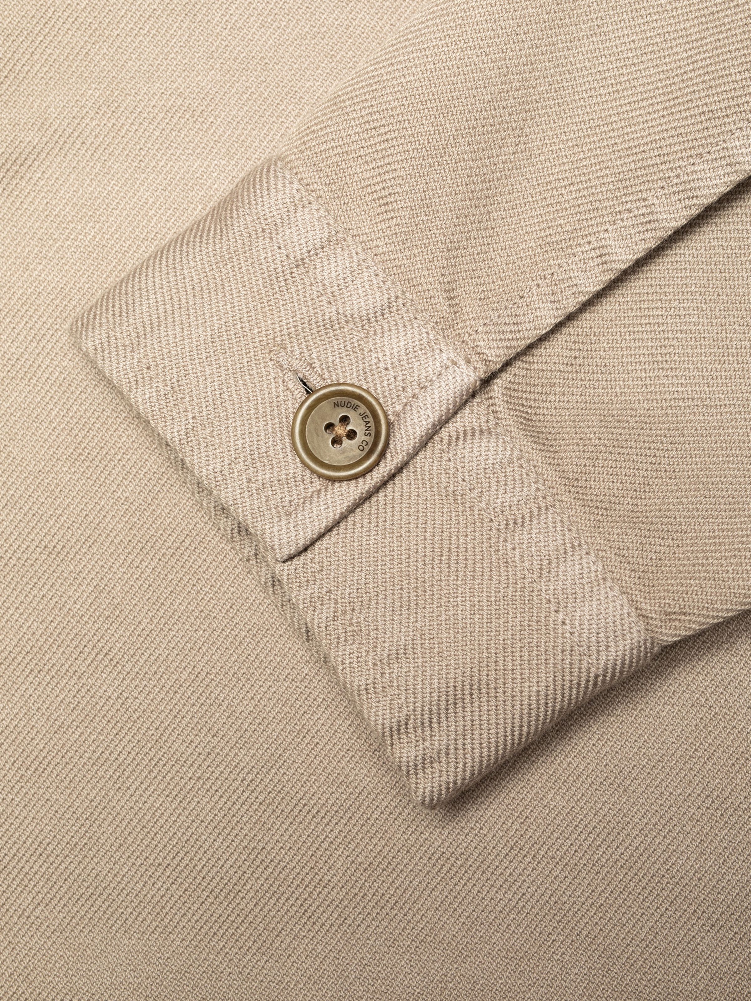 Nudie Jeans Barney Worker Jacket in Mud, close-up of the one-button cuff showing the twill fabric texture.