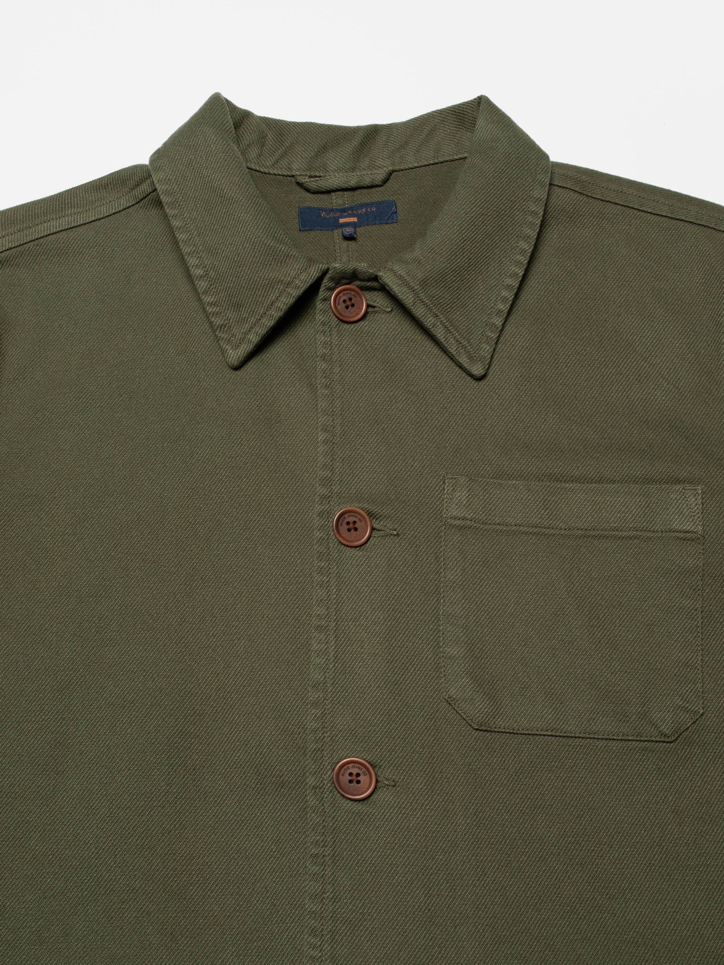 Nudie Jeans Barney Worker Jacket in Olive, a close-up view showing the collar, buttons, and chest pocket.