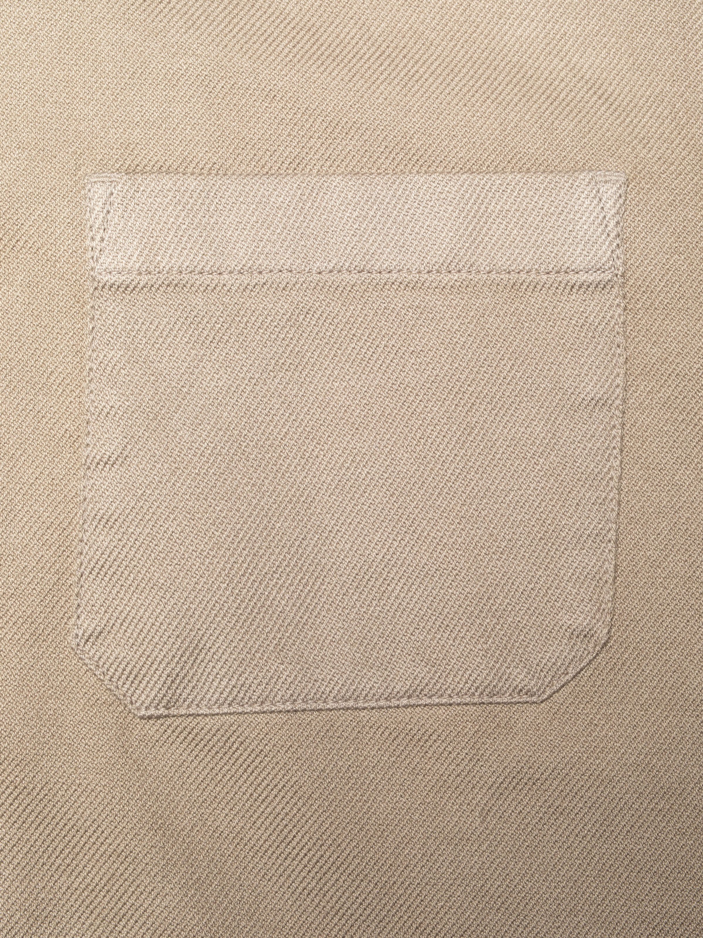 Nudie Jeans Barney Worker Jacket Mud, close-up of a patch pocket showing the organic cotton twill fabric.