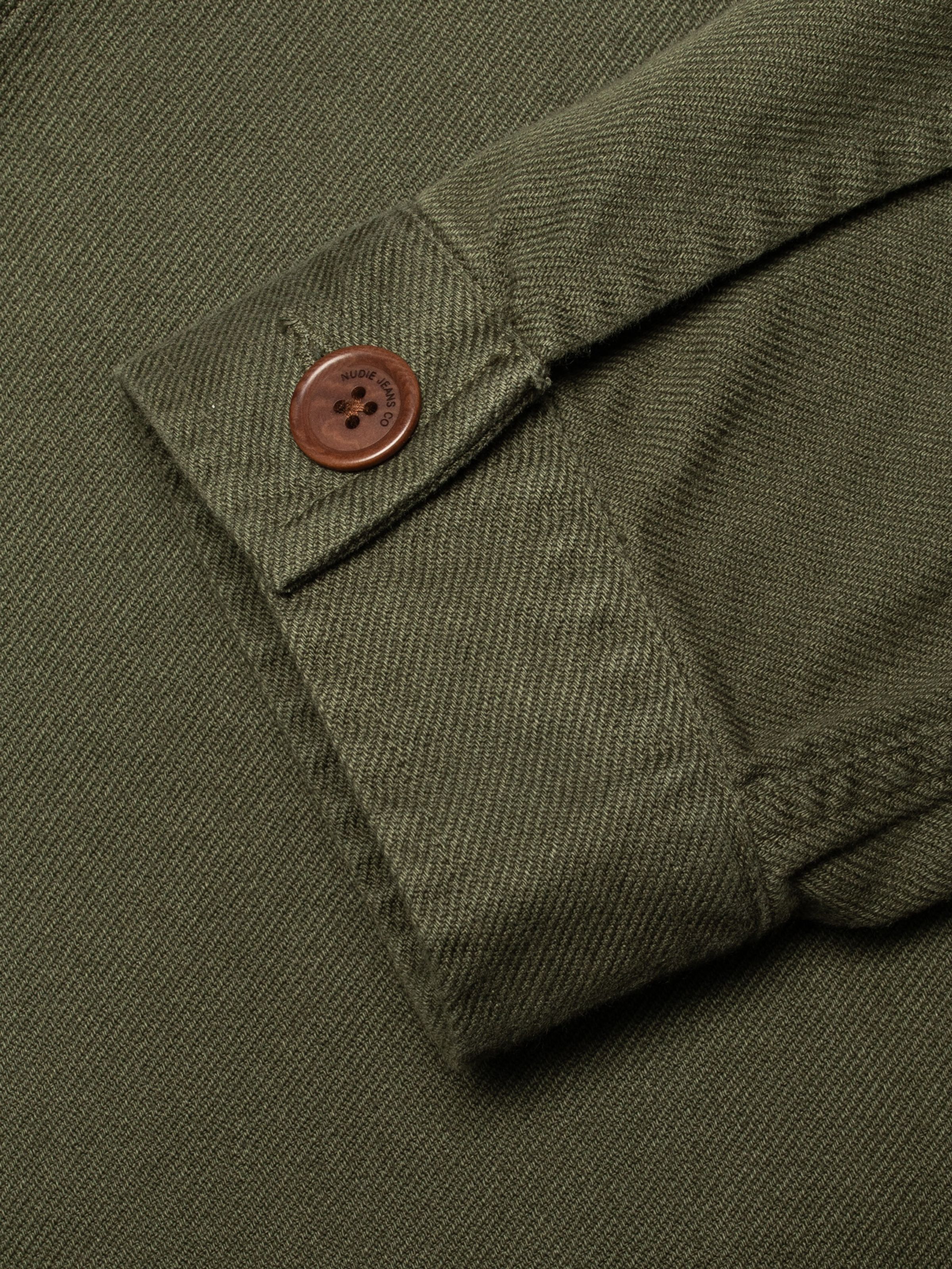 Nudie Jeans Barney Worker Jacket in Olive, close-up of the one-button cuff showing the twill fabric and branded button.