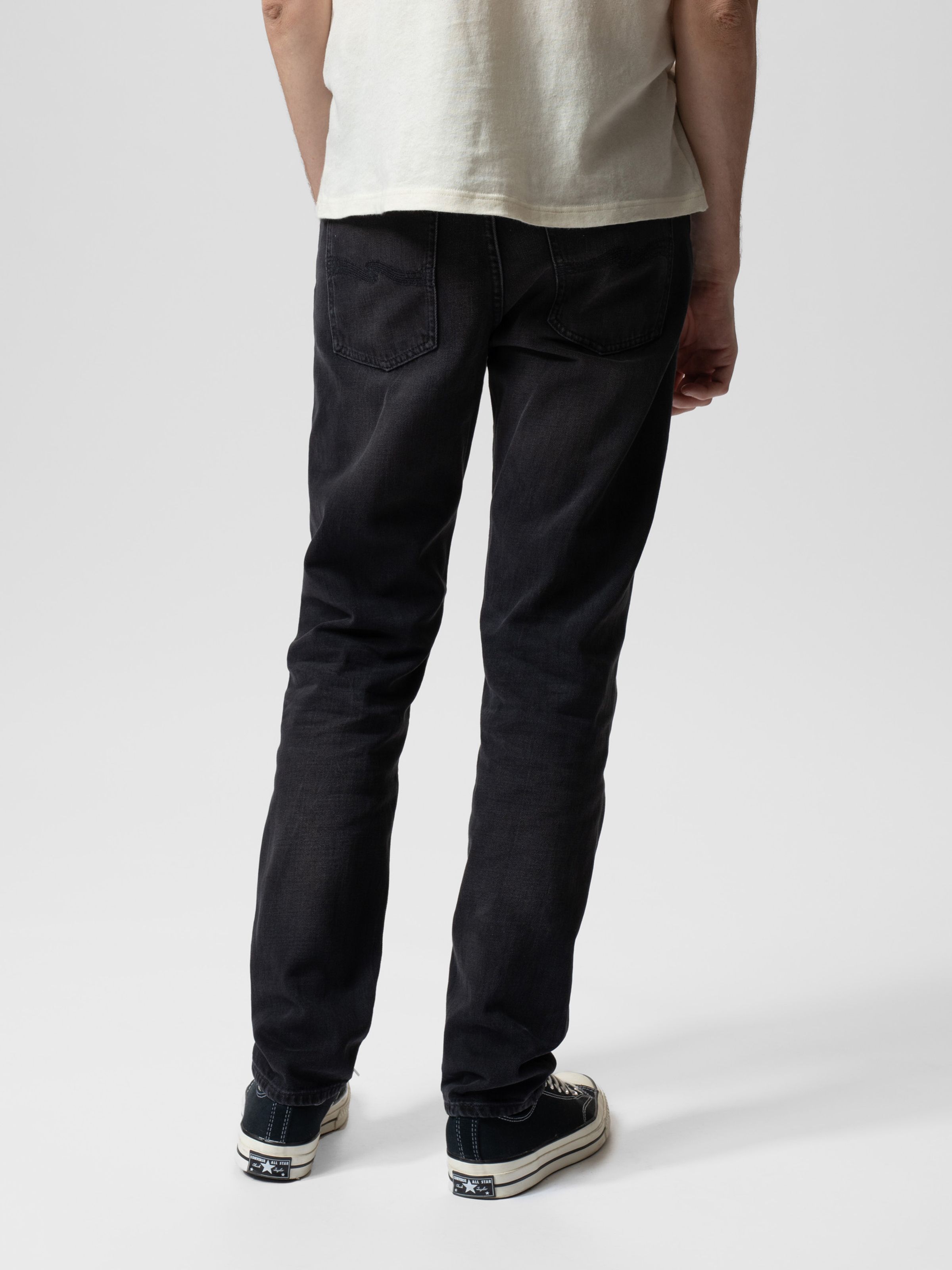 Nudie Jeans Steady Eddie II in Black Change, a pair of men's regular tapered fit jeans shown on a model from the back.