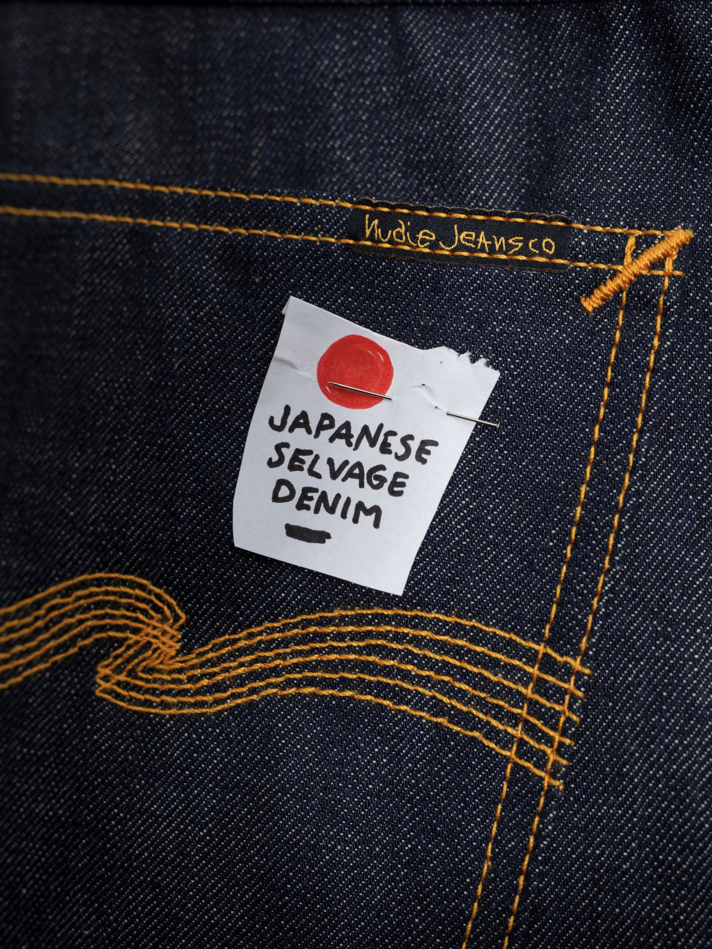 Nudie Jeans Gritty Jackson, close-up of the back pocket with a Japanese selvedge denim tag and orange embroidery.