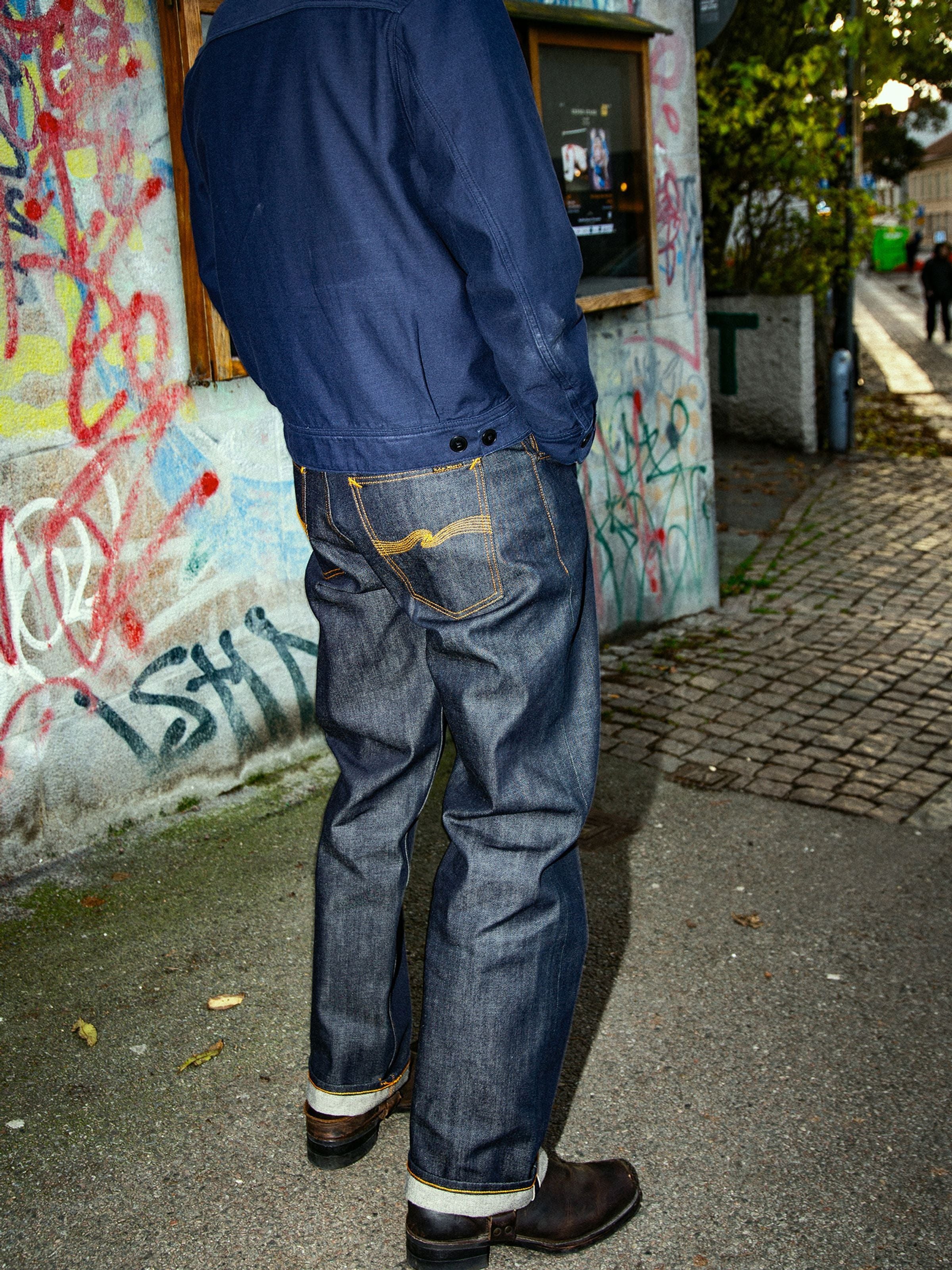 Nudie Jeans Tuff Tony Dry Selvedge, men's loose fit jeans in dry blue selvedge denim, lifestyle shot from behind.