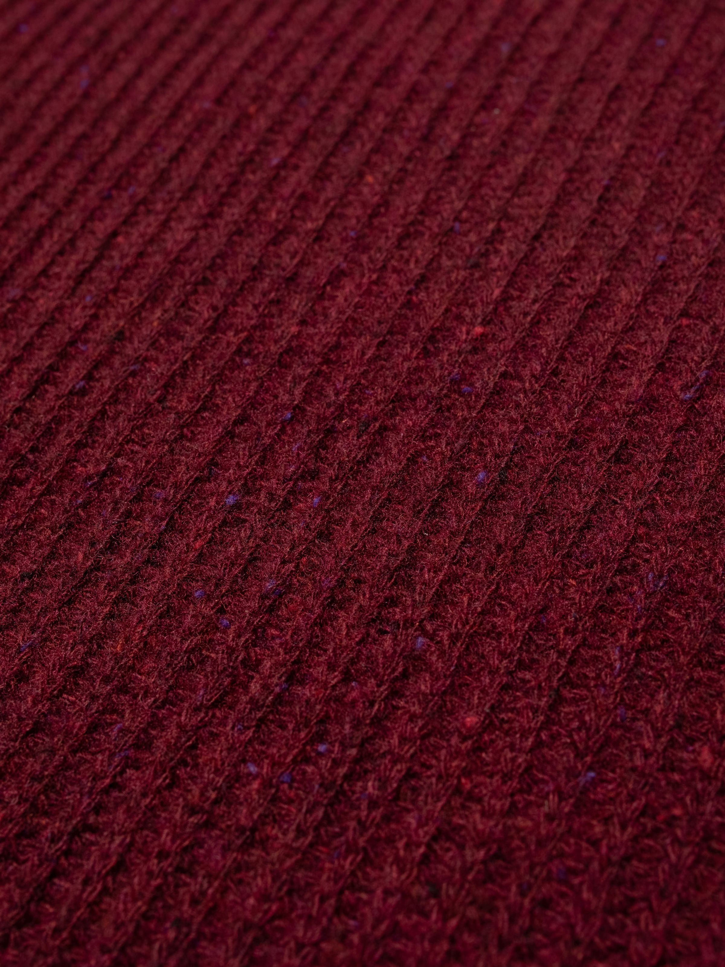 Nudie Jeans August Rib Wool Sweater in Burgundy, close-up of the organic wool in a textured full cardigan stitch.