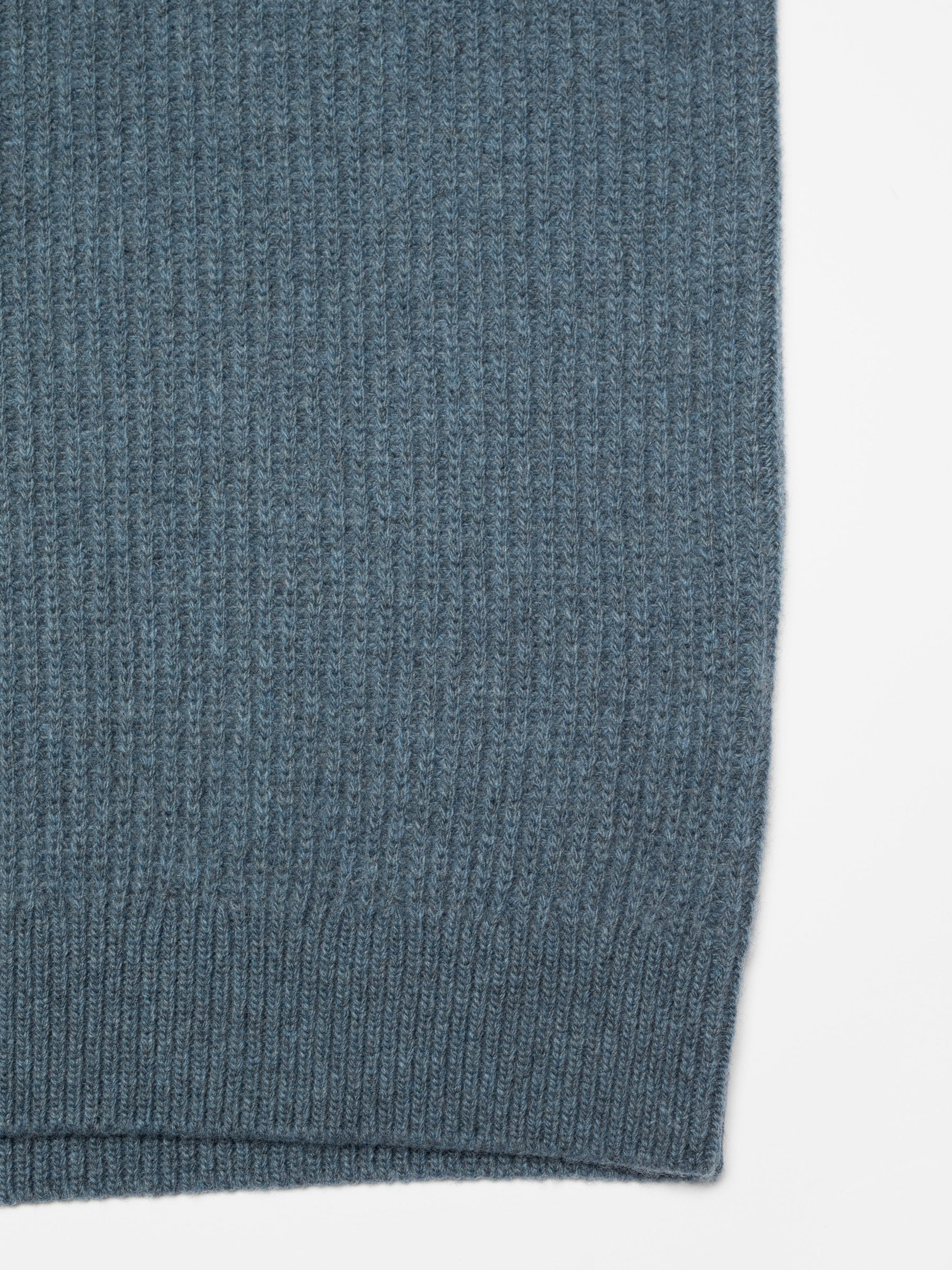 Nudie Jeans August Rib Wool Sweater in Blue Melange, a close-up showing the ribbed knit texture and hem of the sweater.