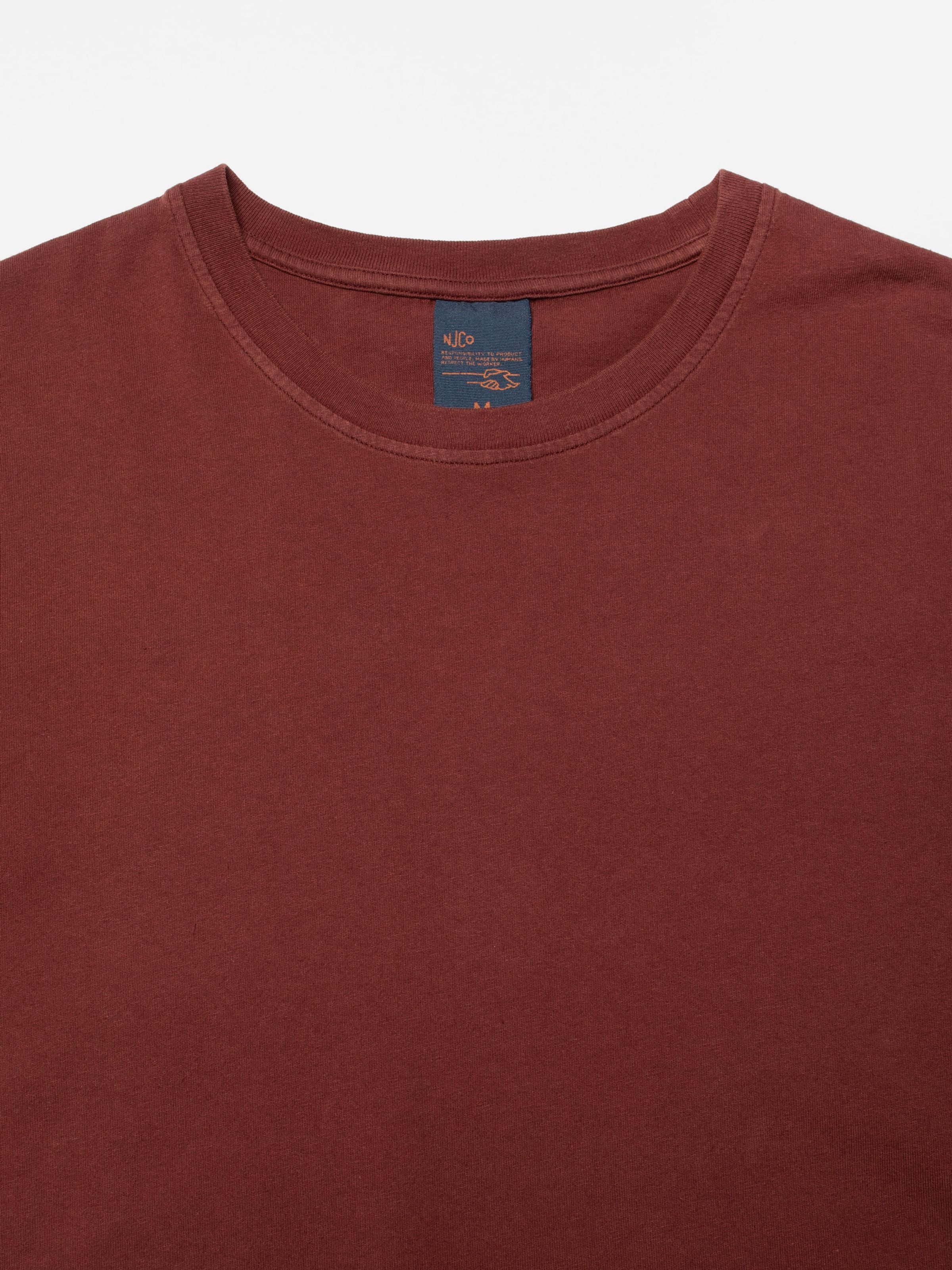 Nudie Jeans Uno Everyday T-Shirt in burgundy organic cotton, close-up of the crew neck and internal brand label.