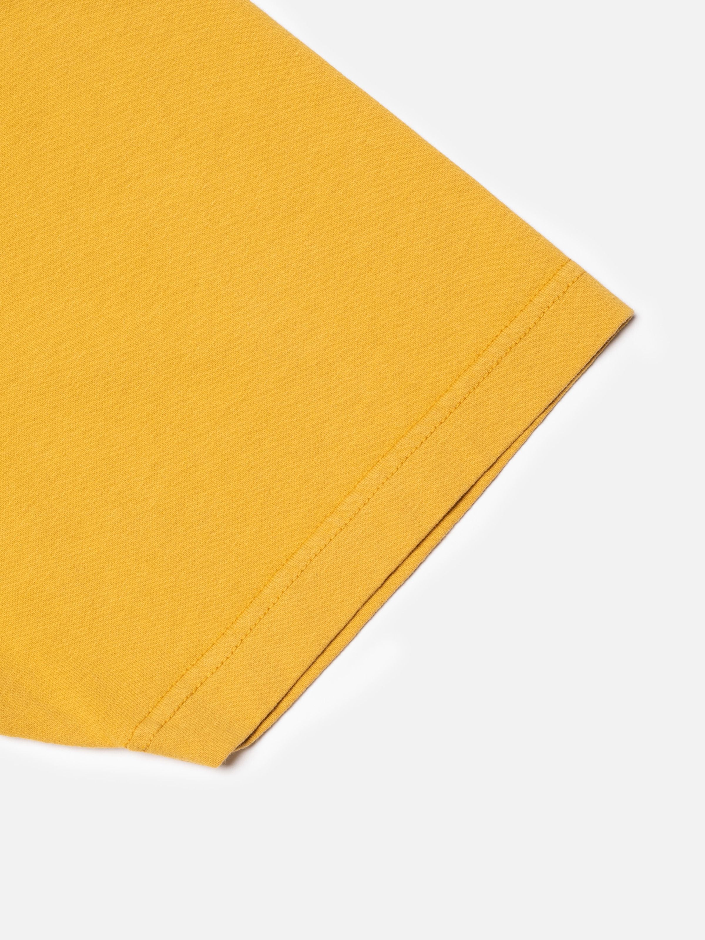 Nudie Jeans Uno Everyday T-Shirt, close-up showing sleeve hem and organic cotton jersey texture in old yellow.