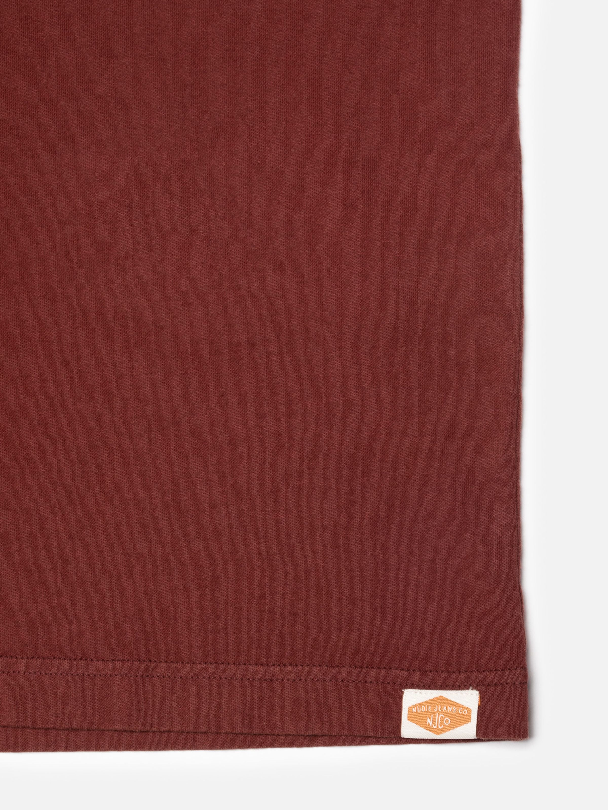 Nudie Jeans Uno Everyday T-Shirt in burgundy, close-up of the pigment-dyed organic cotton jersey and bottom hem.
