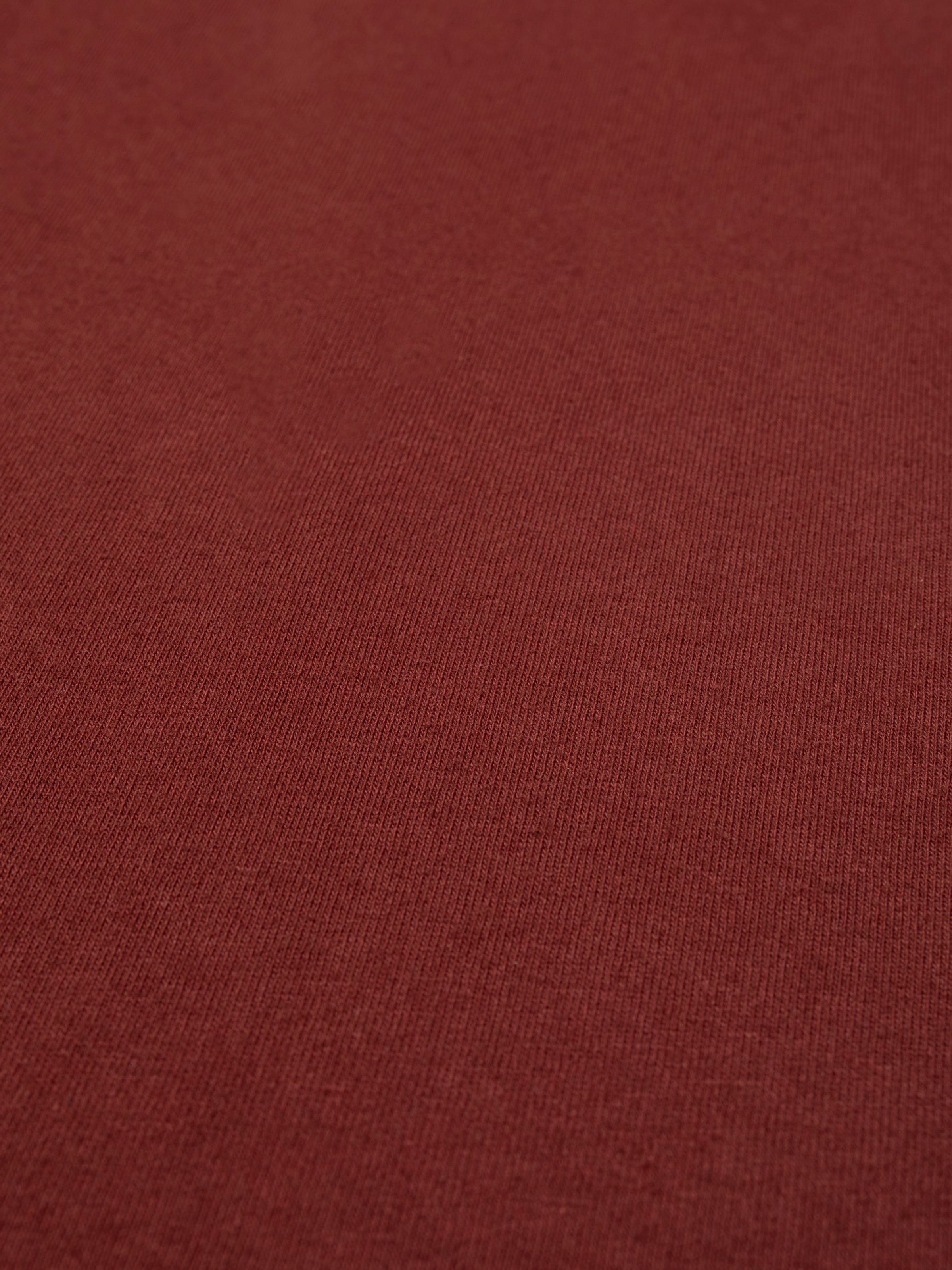 Nudie Jeans Uno Everyday T-Shirt in Burgundy, close-up showing the texture of the organic cotton jersey fabric.