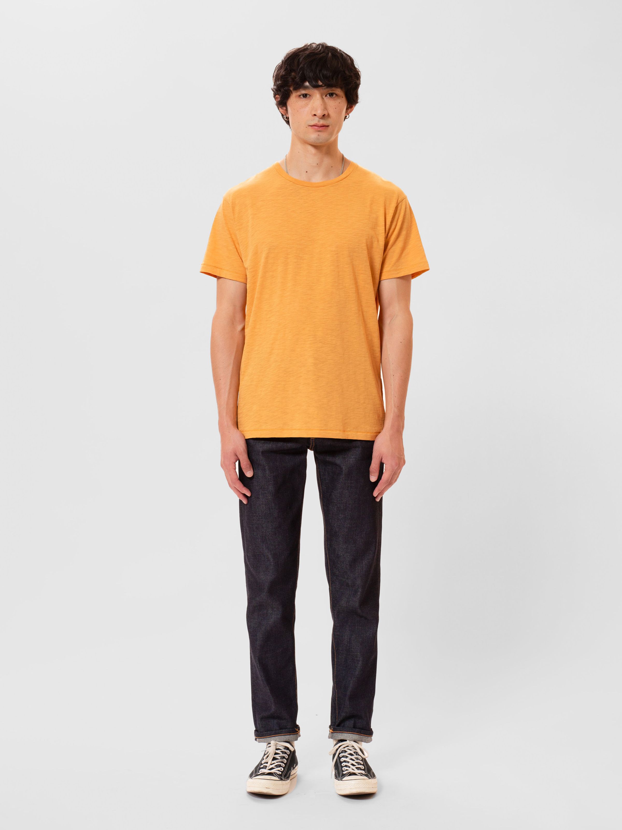 Nudie Jeans Roffe T-shirt in Ochre, a men's regular fit t-shirt, shown on a model against a white background.