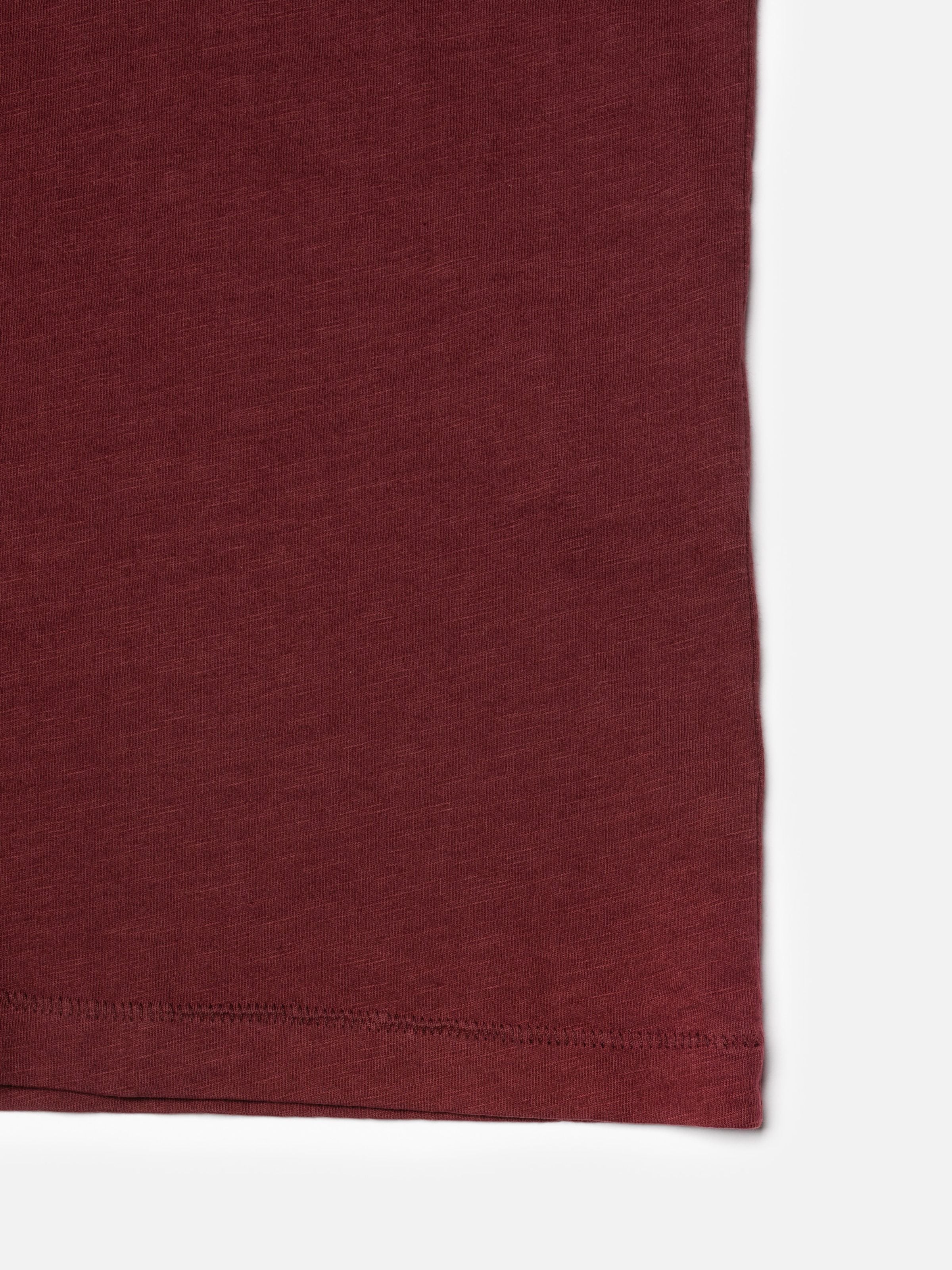 Nudie Jeans Roffe Slub T-Shirt in Burgundy, close-up of the organic cotton fabric and mouse teeth hem stitching.