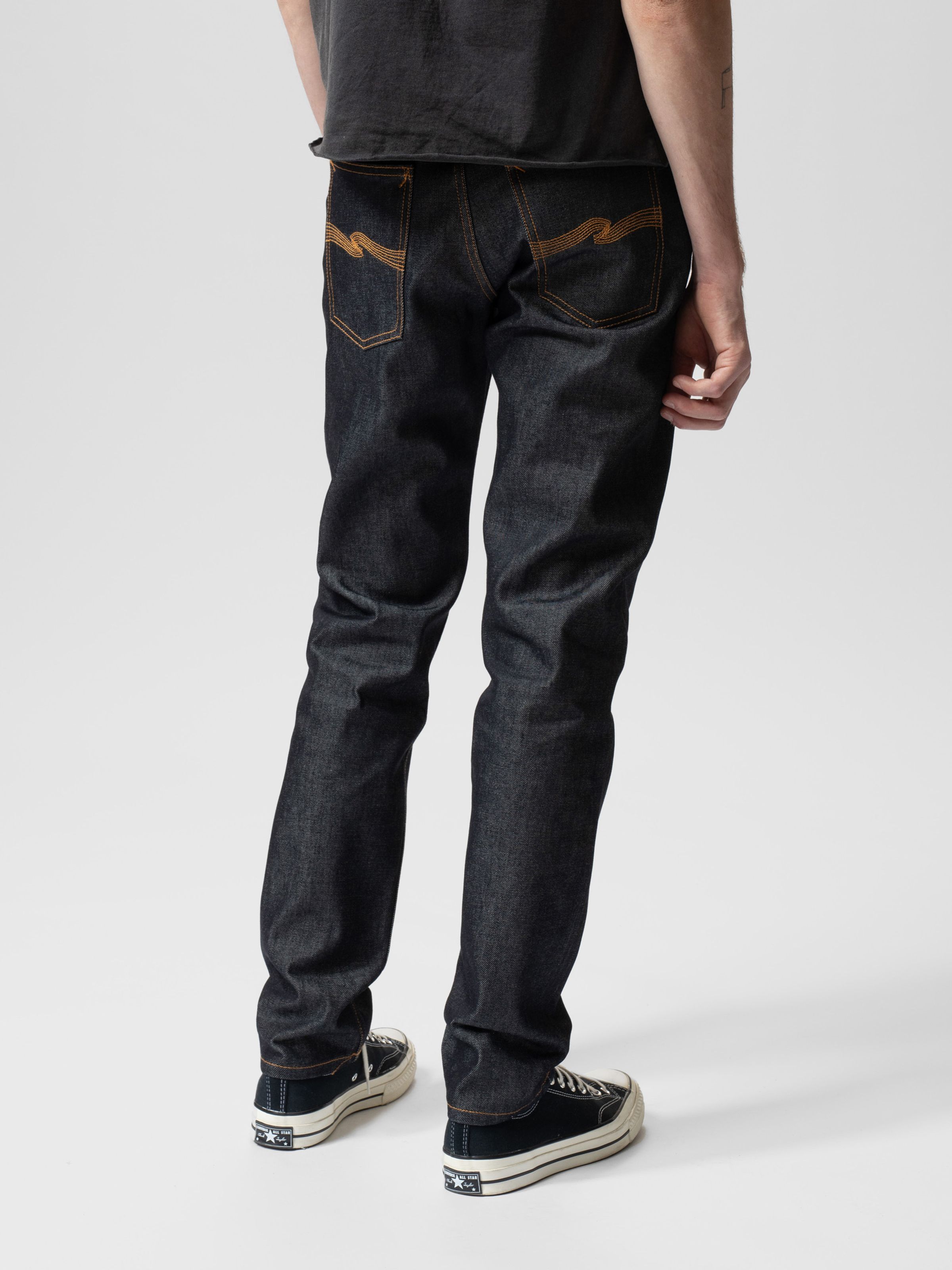 Nudie Jeans Steady Eddie II in Dry Heavy, a men's regular tapered fit jean, shown from the back on a model.