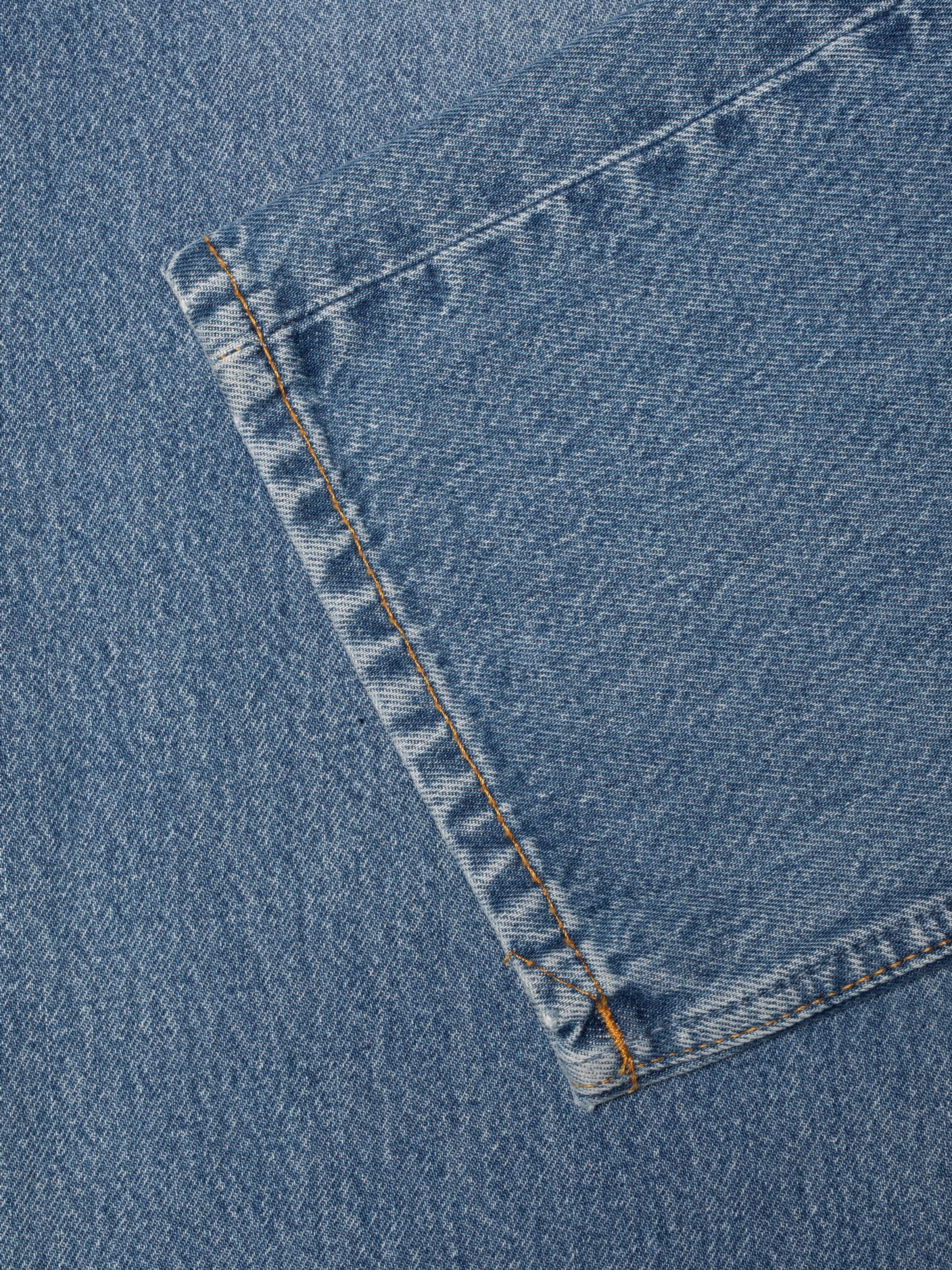 Nudie Jeans Rad Rufus Indigo Blues, regular straight jeans, showing a close-up of the hem and denim fabric texture.