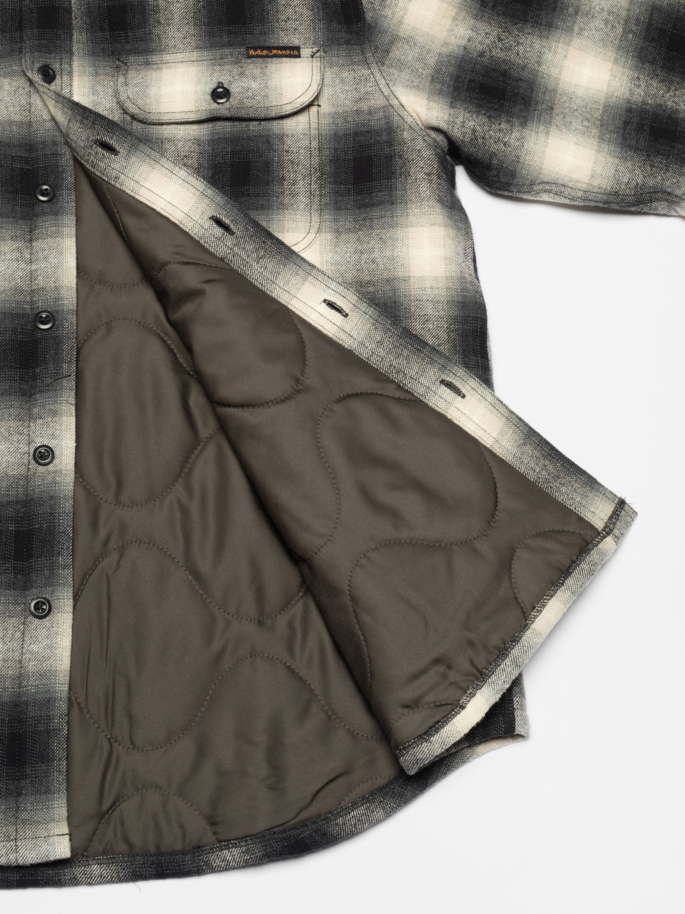 Nudie Jeans Glenn Padded Shadow Check Shirt Black, a men's flannel overshirt, in a close-up of its quilted lining.