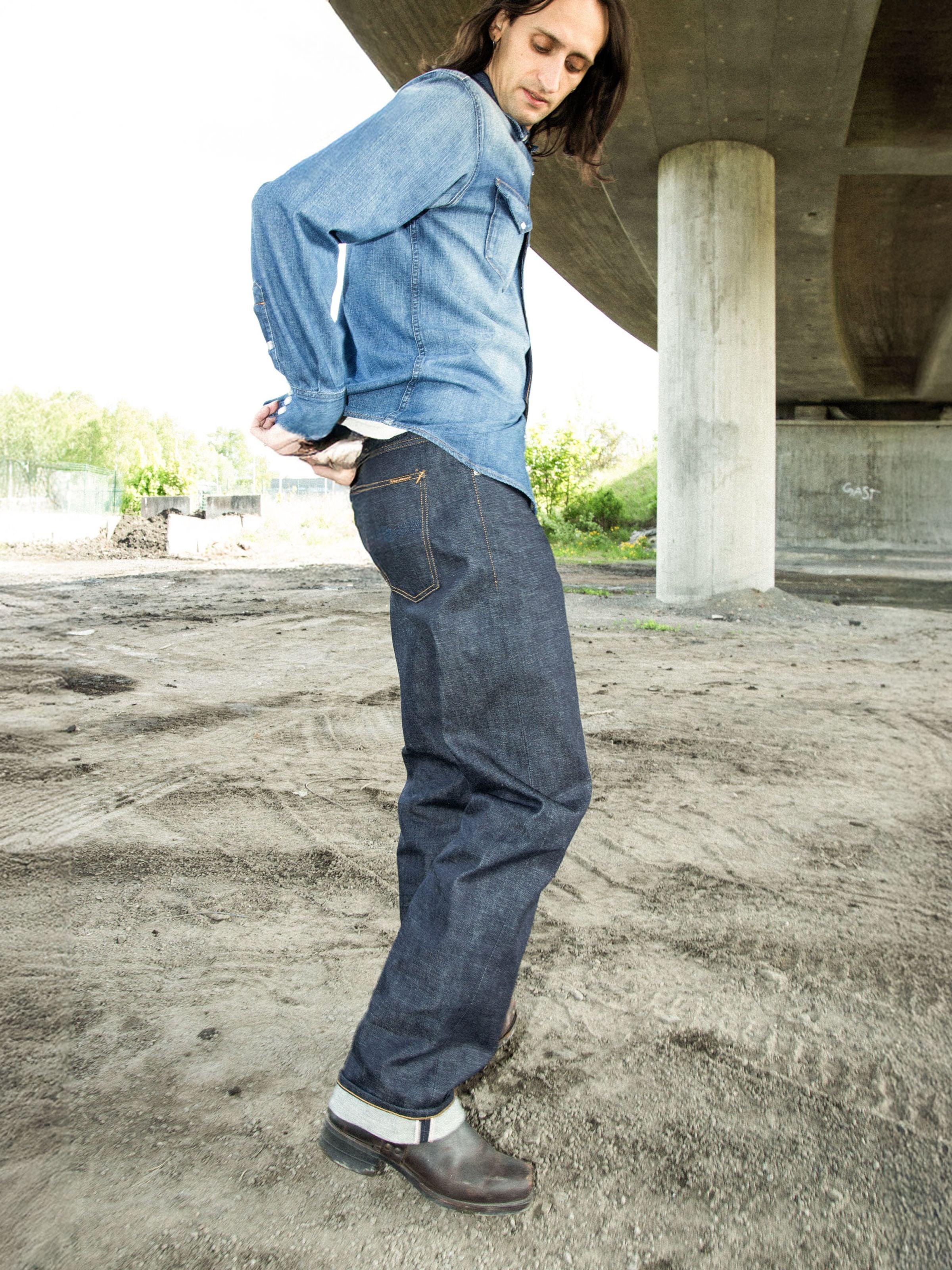 Nudie Jeans Tuff Tony Dry Ace Selvage, weite Rigid-Jeans aus Redcast Bio-Baumwoll-Selvedge-Denim, von einem Model getragen.