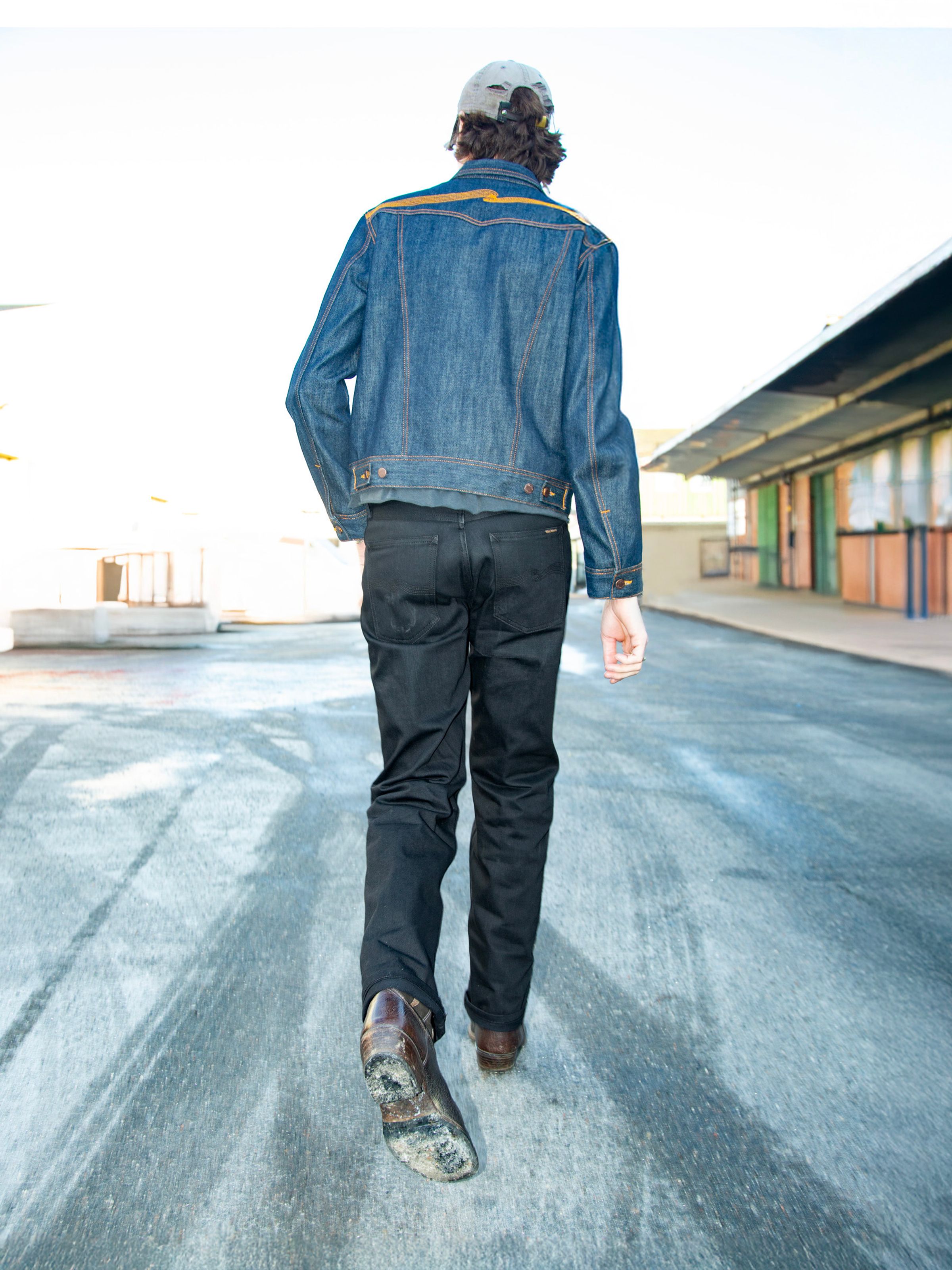 Nudie Jeans Rad Rufus Dry Black Selvage, men's regular fit straight leg jeans shown from the back on a model.