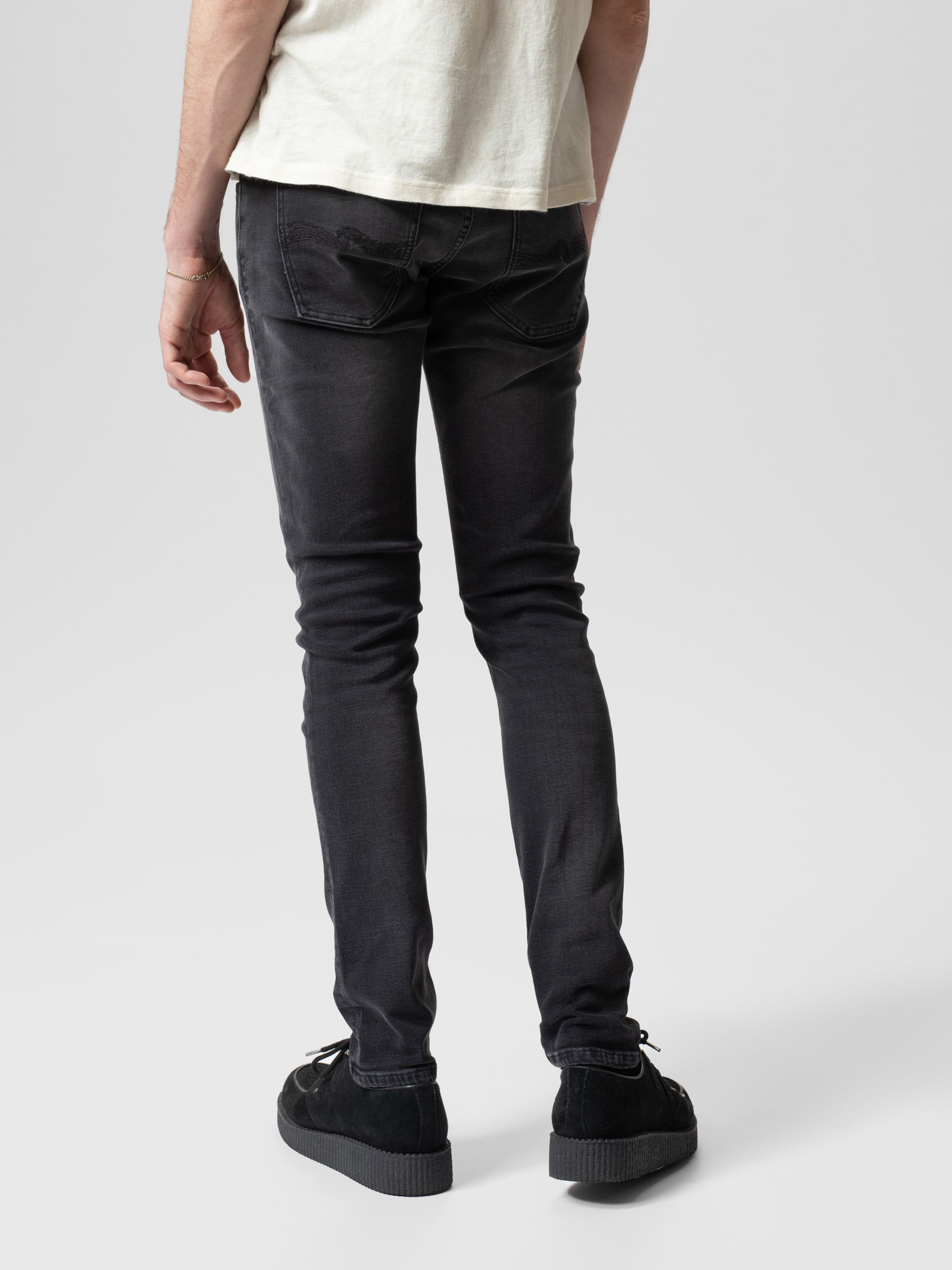 Nudie Jeans Tight Terry in Black Blizzard, men's tight fit jeans shown on a model from the back.