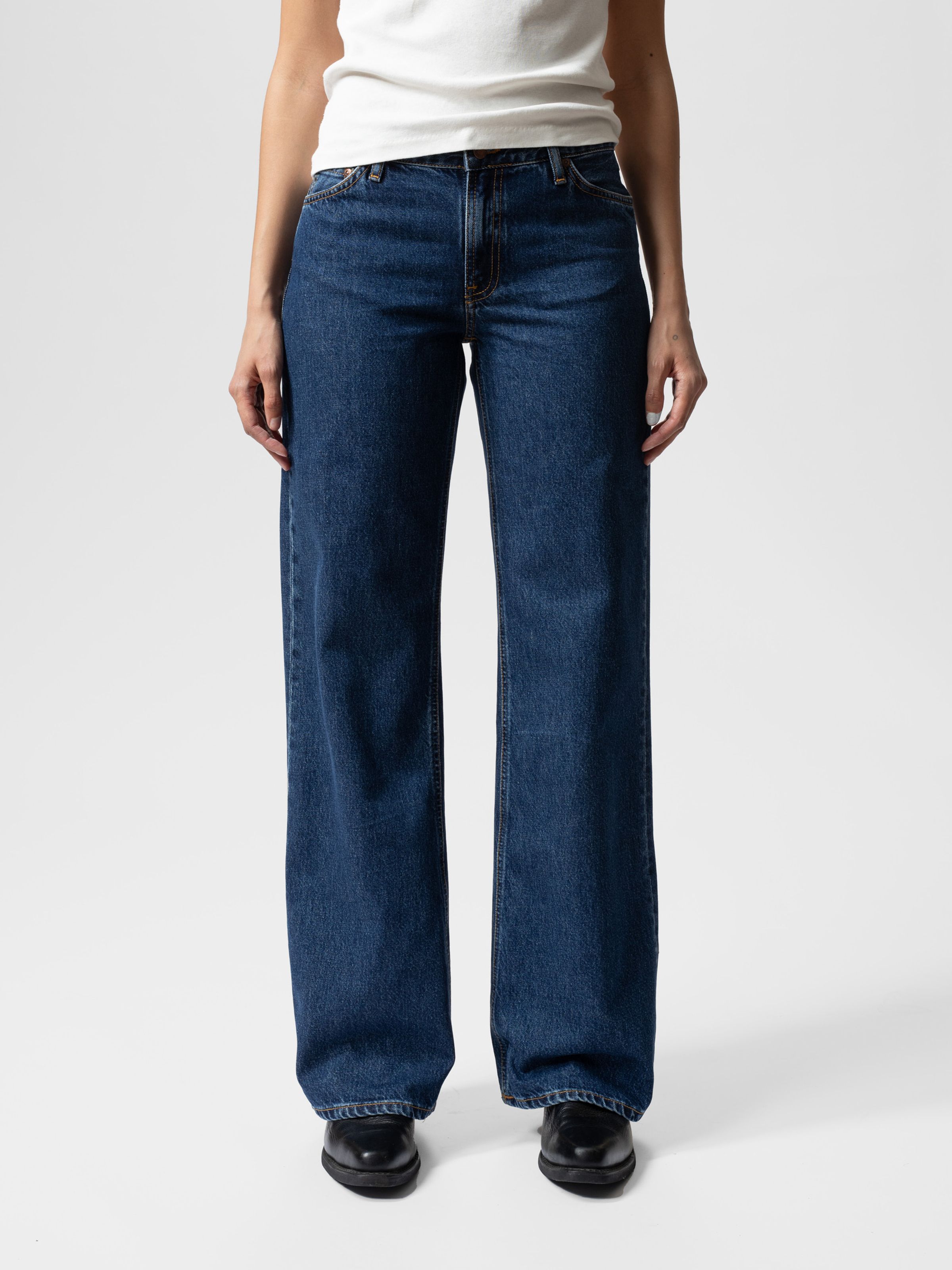 Nudie Jeans Wide Heidi Evening Jazz, women's loose wide-leg jeans in dark blue stonewash, shown from the front on a model.