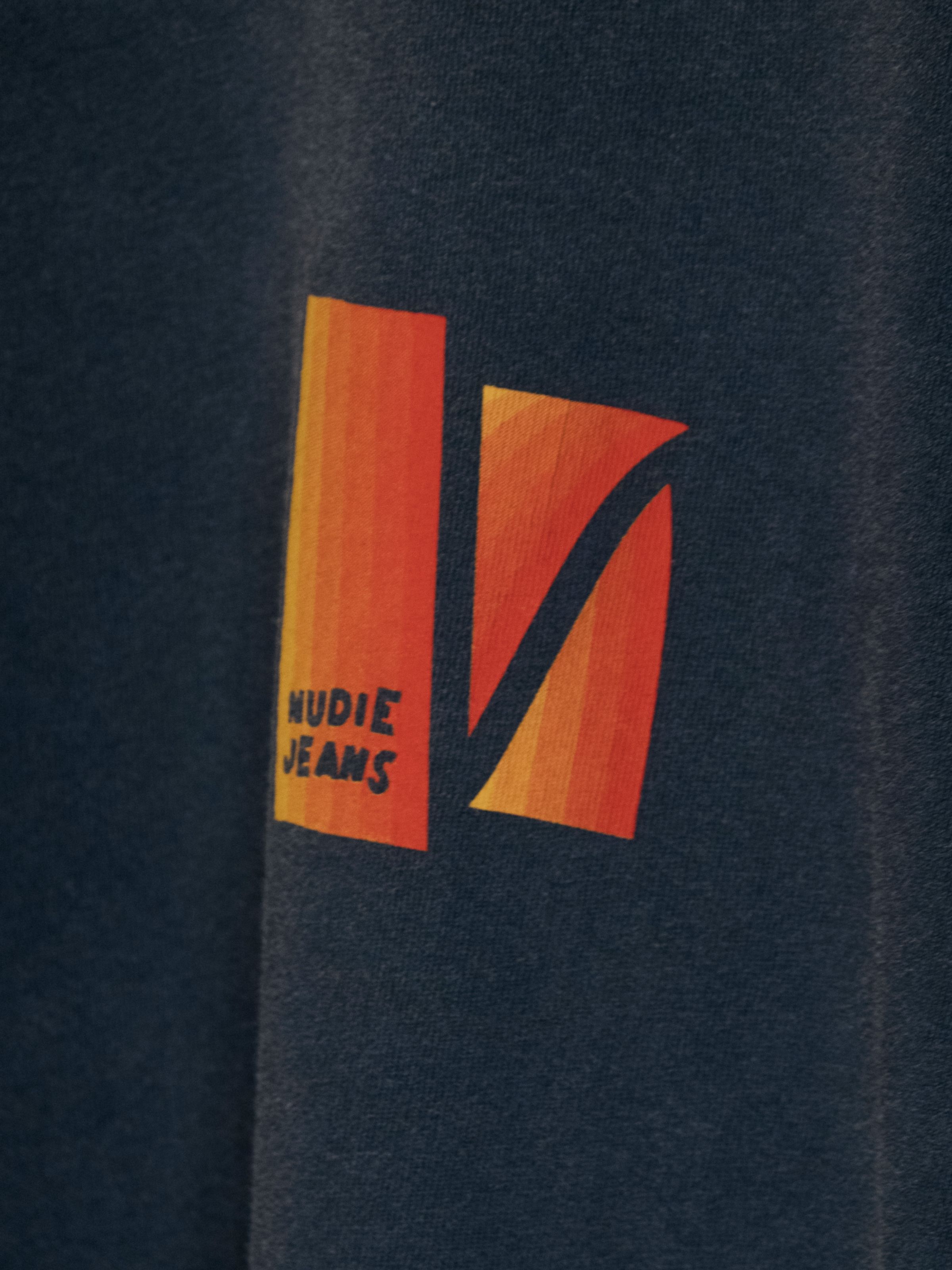 Nudie Jeans Roy Sunburns T-Shirt in Antracite, a men's t-shirt with a close-up view of the orange and yellow chest print.
