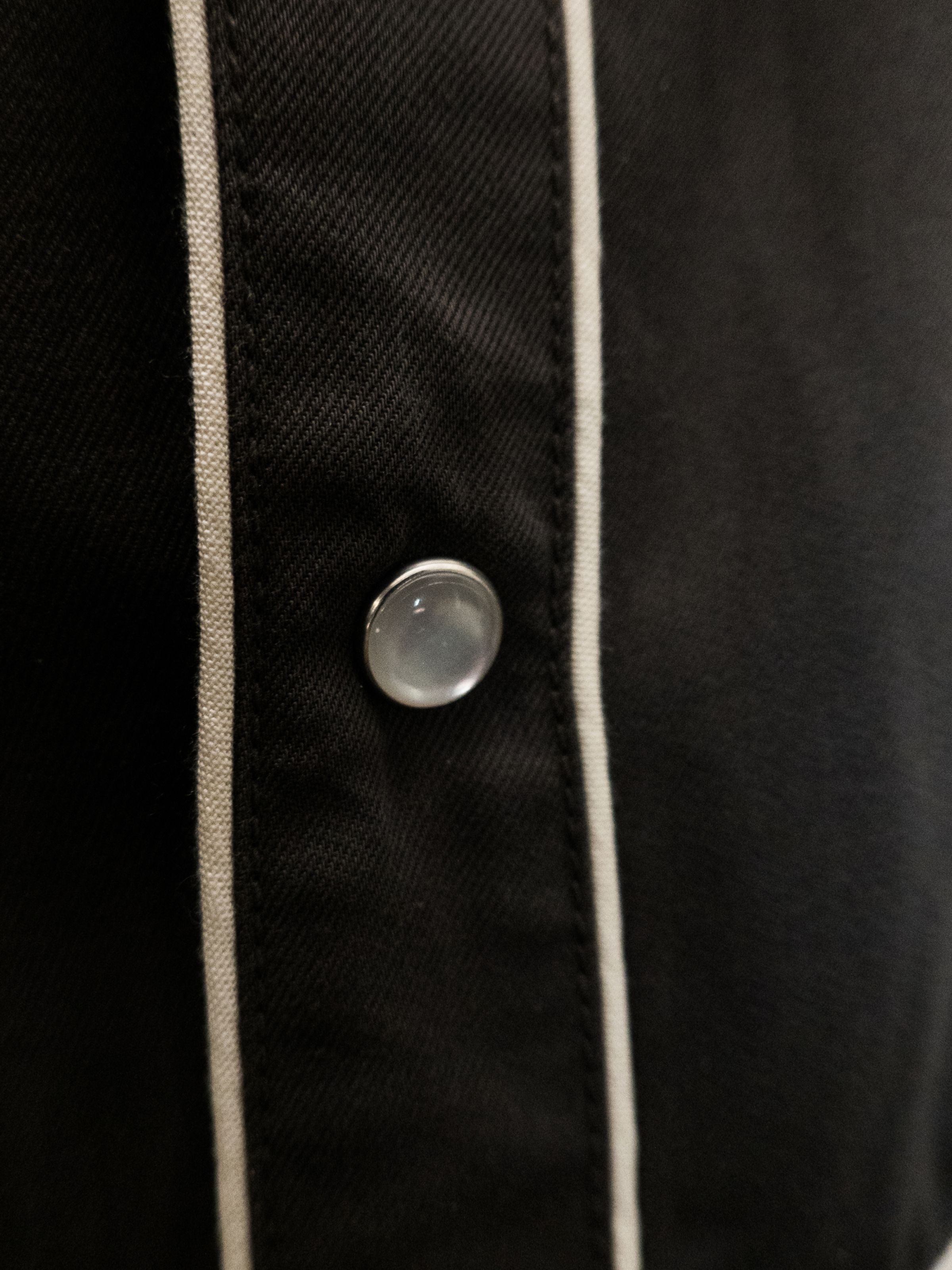 Nudie Jeans Gonzo Western Shirt Sunburns, a men's western shirt, shown in a close-up of the pearl snap button and piped seam.