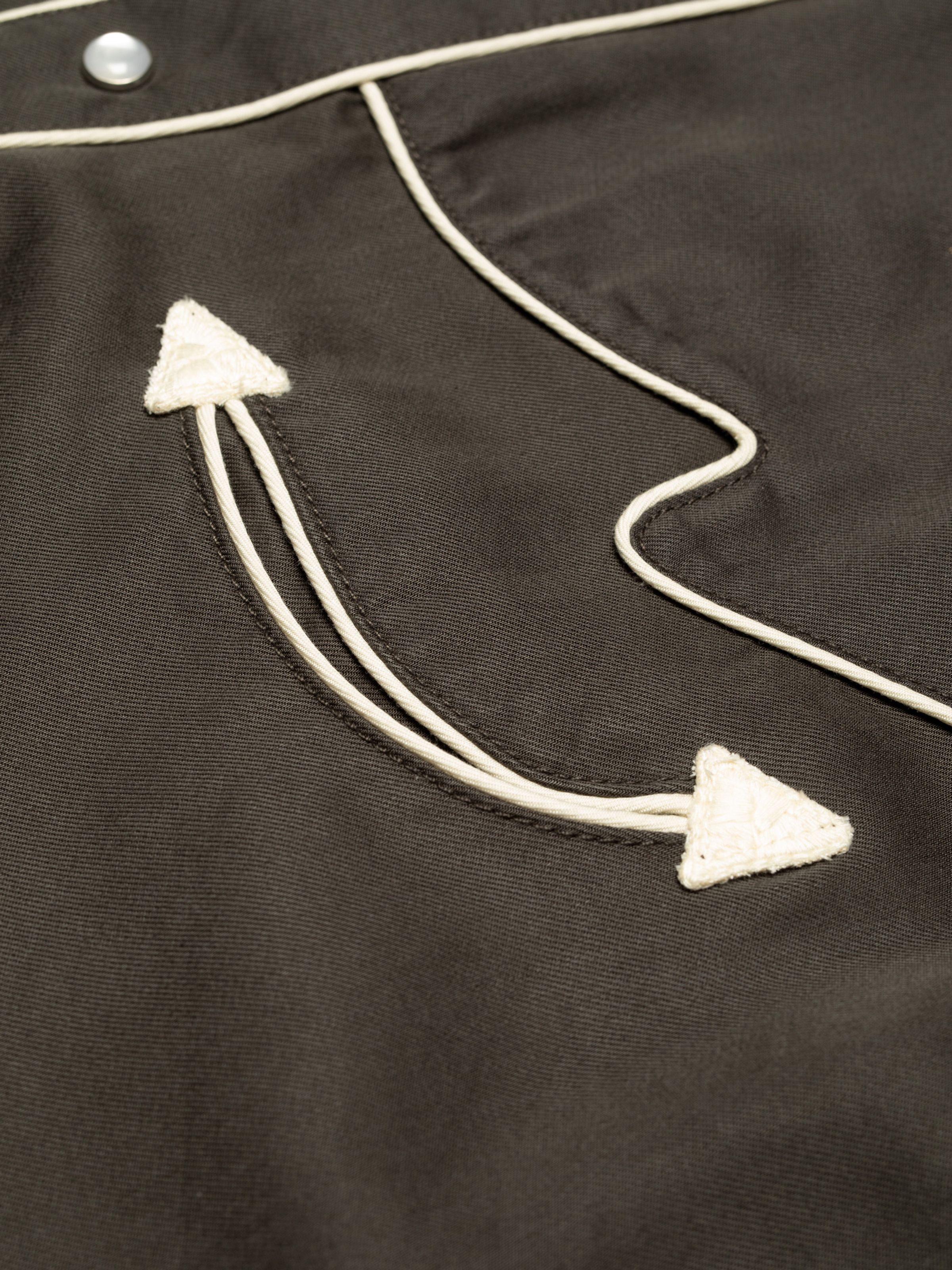 Nudie Jeans Gonzo Western Shirt Sunburns in black/brown, showing a close-up detail of the piped seam and chest embroidery.