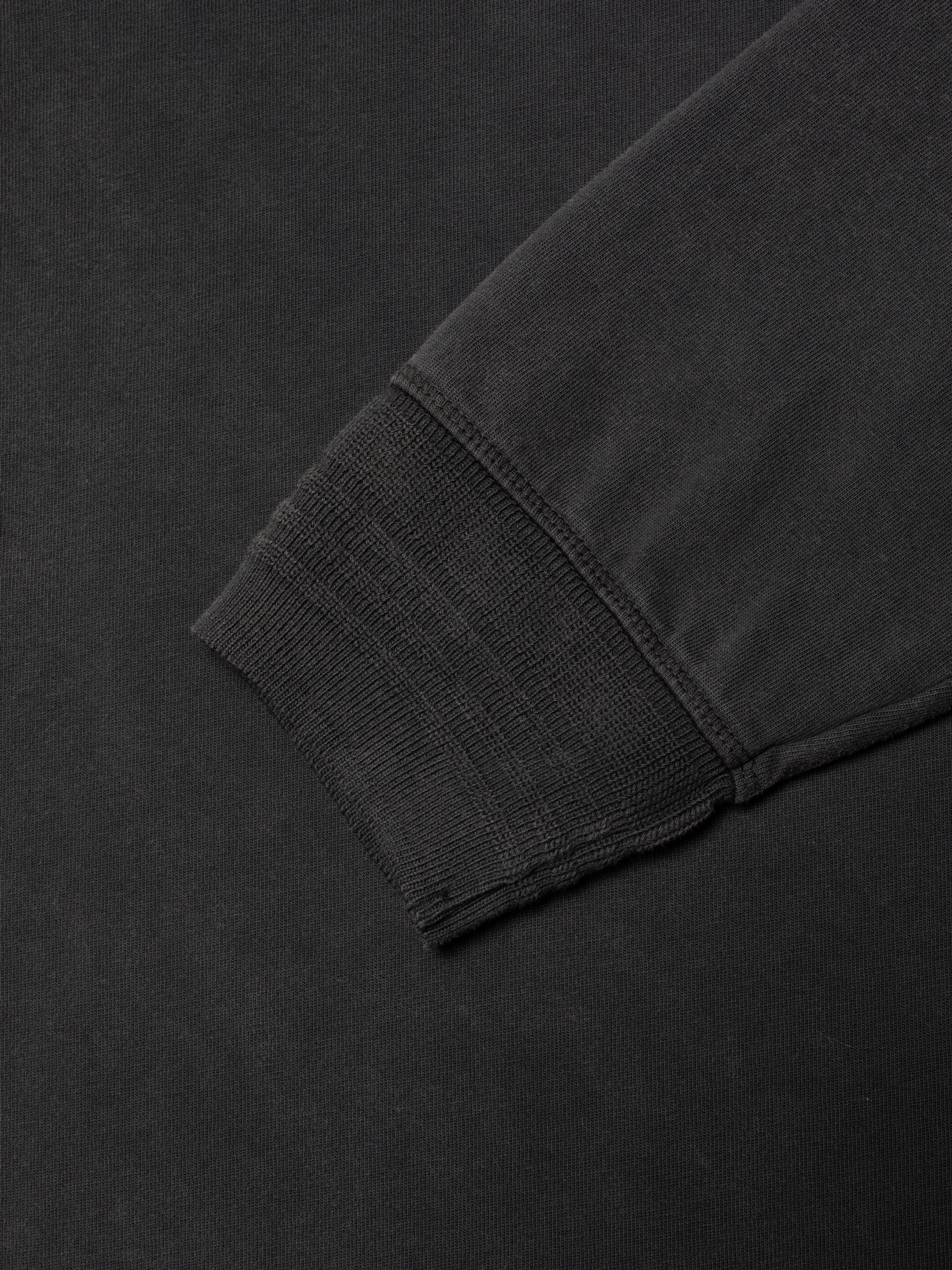 Nudie Jeans LS Henley Washed in Antracite, close-up detail of the ribbed sleeve cuff on the organic cotton shirt.