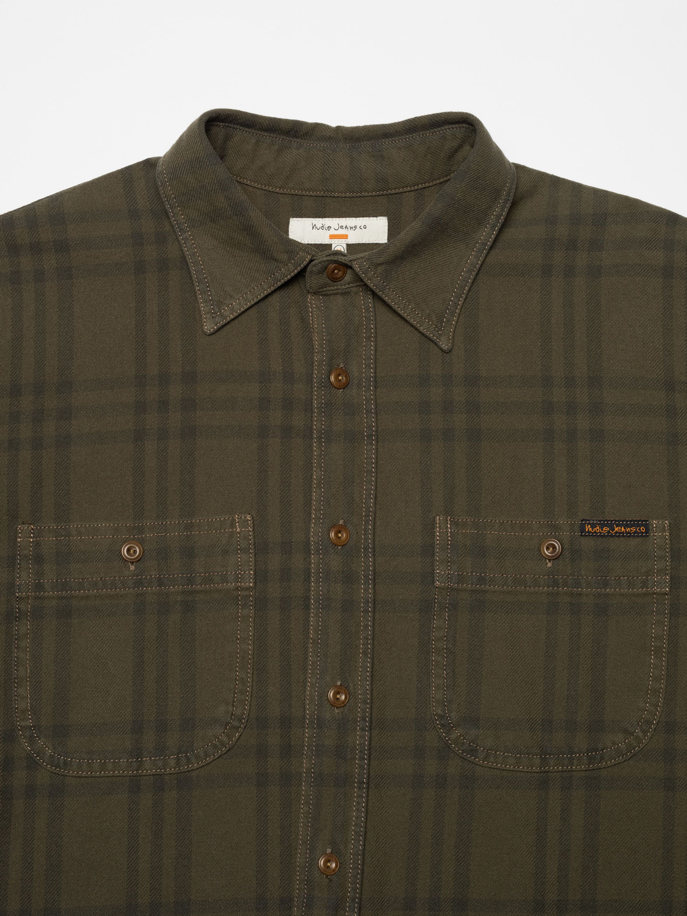 Nudie Jeans Julian Worker Plaid Check Shirt in Olive, a close-up showing the collar, button placket, and dual chest pockets.