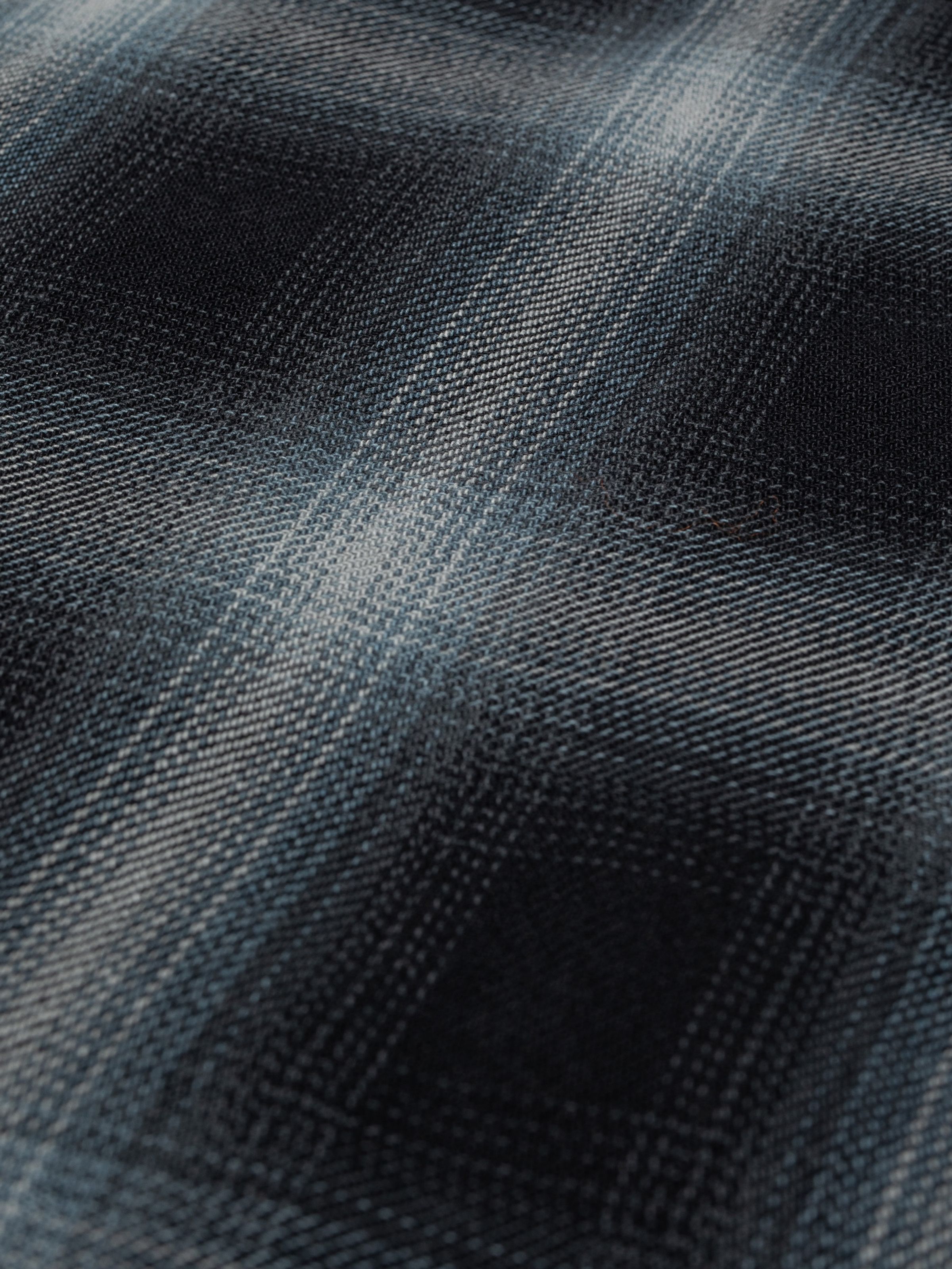 Nudie Jeans Julian Worker Shadow Check Shirt in Black, close-up of the organic cotton twill and shadow check pattern.