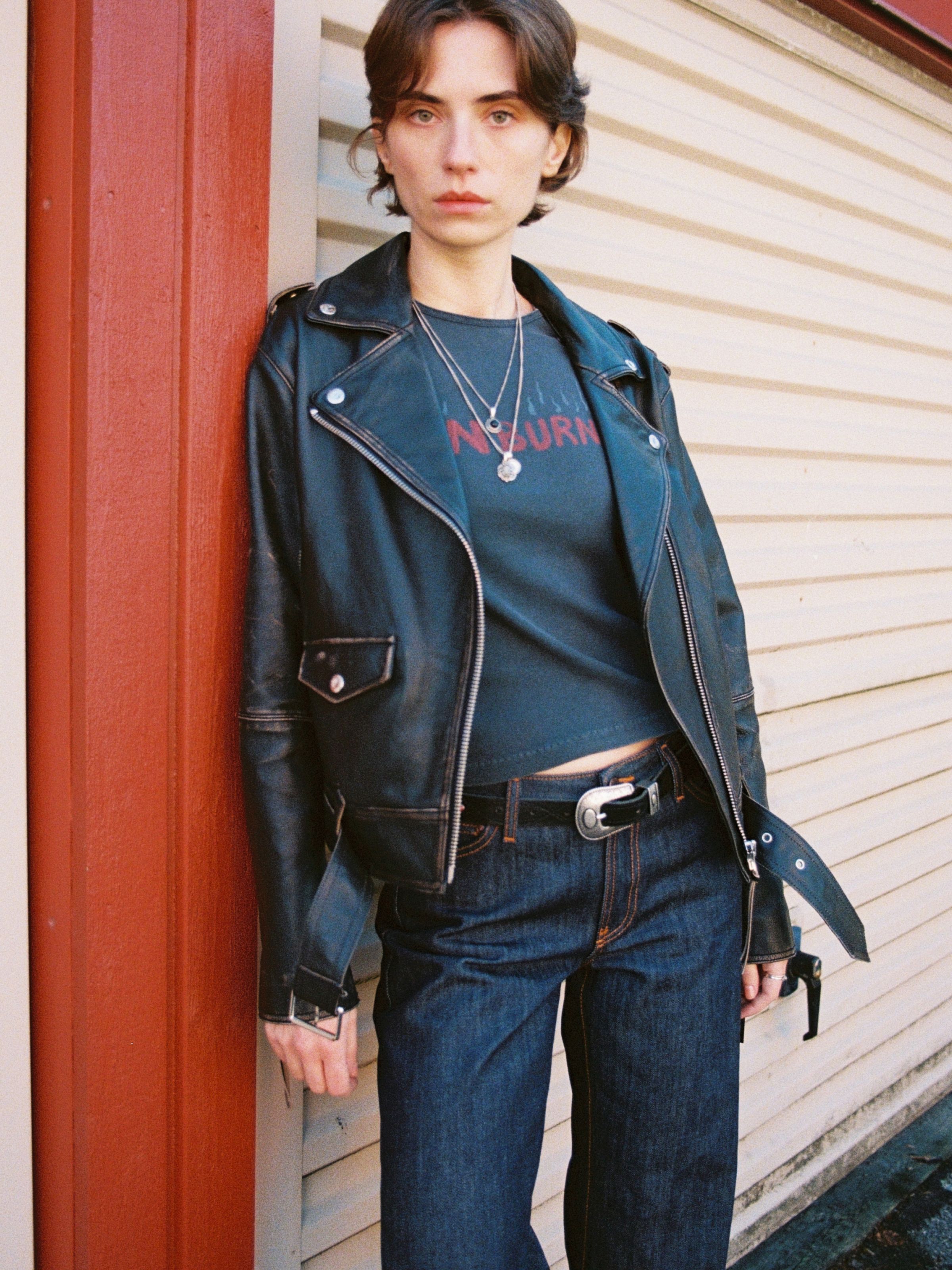 Nudie Jeans Eve Sunburns T-Shirt in black, a women's slim fit tee worn by a model styled with a leather jacket.
