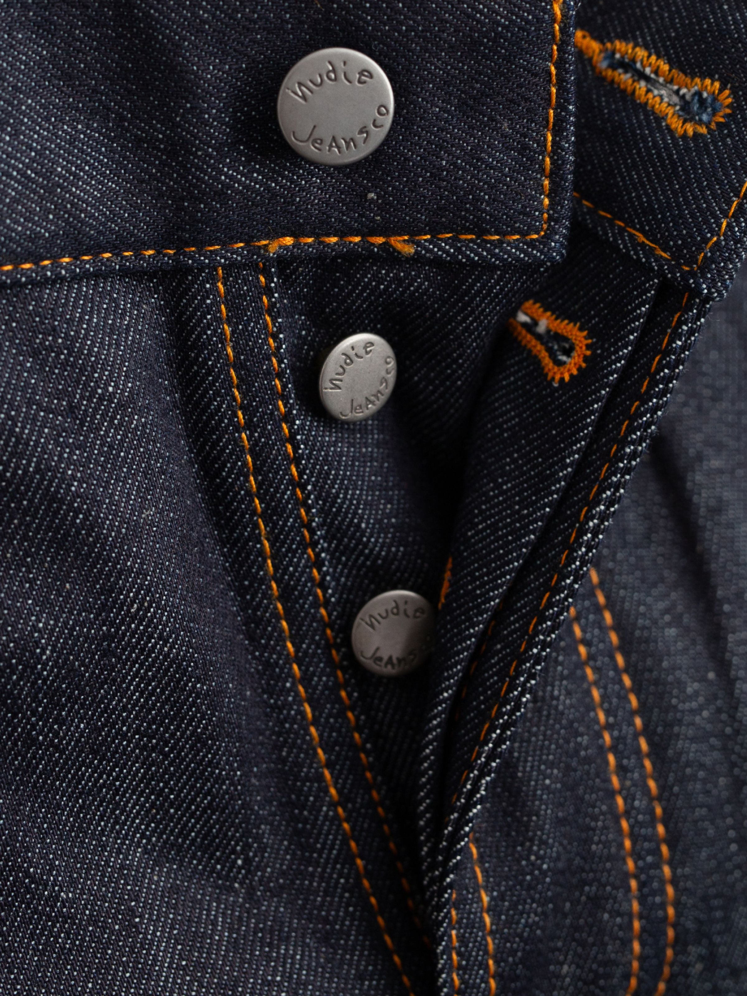 Steady Eddie II Dry Dusk Selvage, Nahaufnahme der Knopfleiste und antiksilbernen Details in Selvedge-Denim.