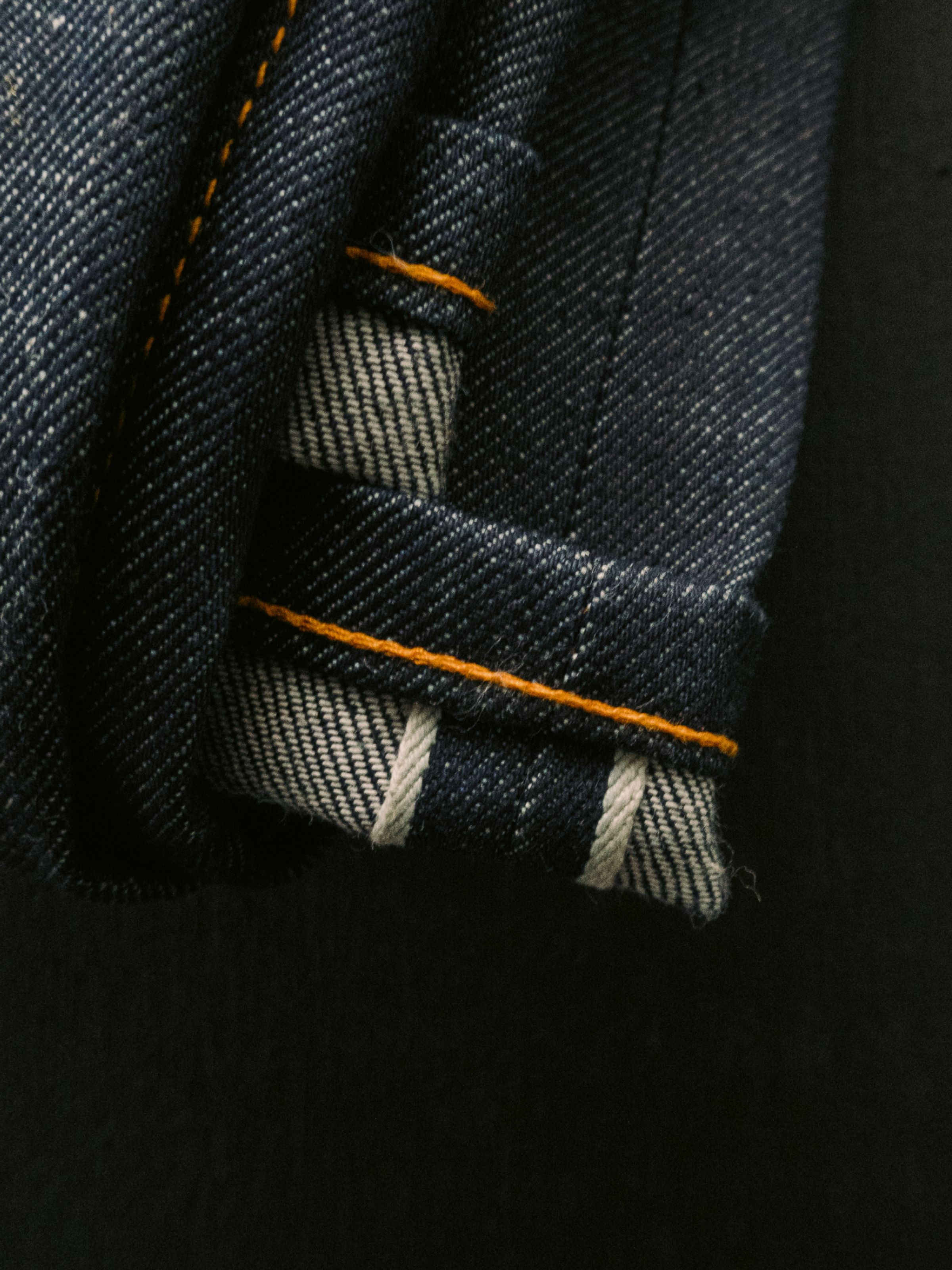 Nudie Jeans Steady Eddie II Dry Dusk Selvage, eine reguläre Tapered-Herrenjeans, in einer Nahaufnahme des Selvage-Aufschlags.