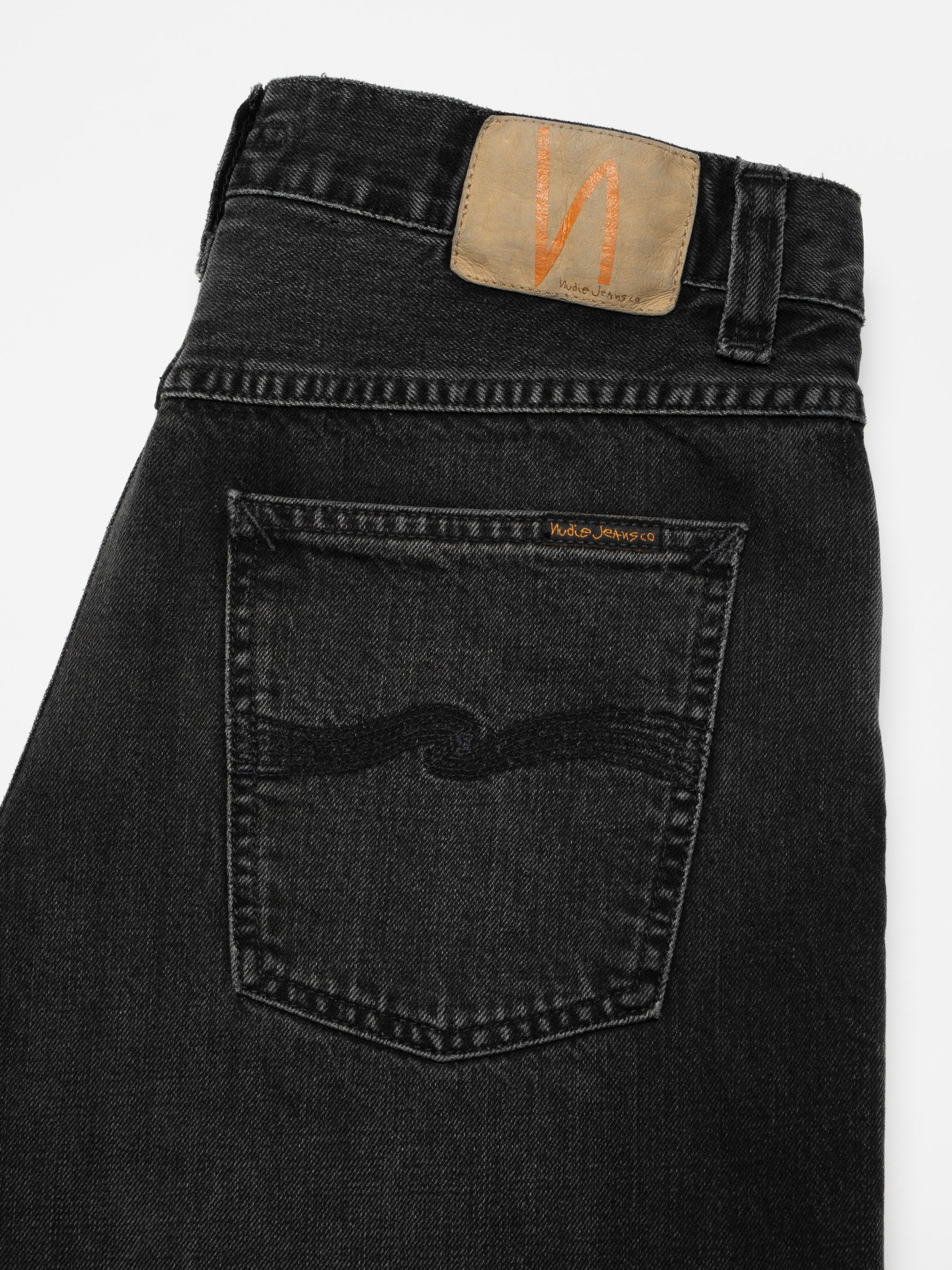 Nudie Jeans Loud Larry Black Storm, men's loose wide leg jeans in black, shown laid flat with a close-up of the back pocket.