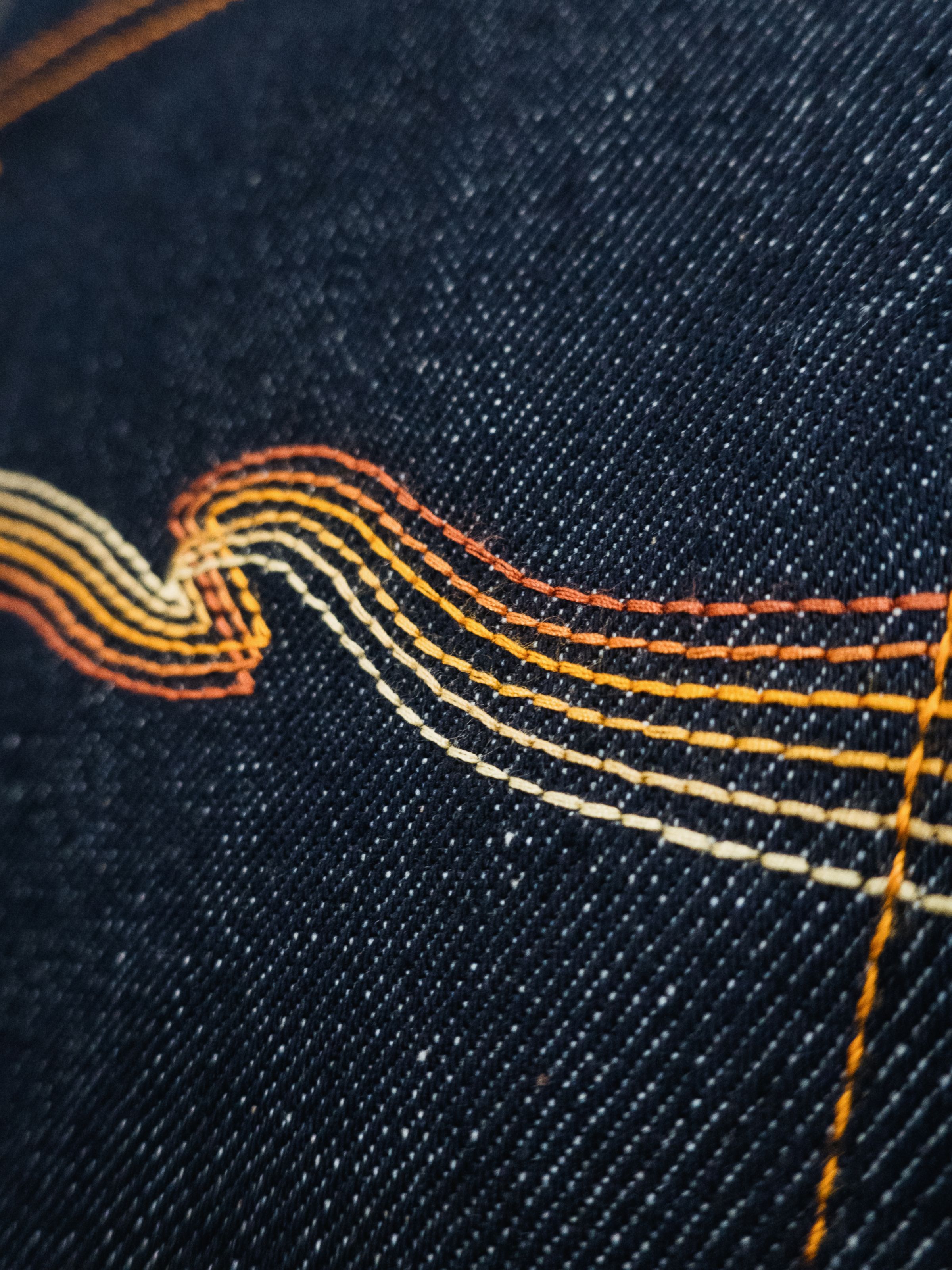 Nudie Jeans Lean Dean Dry Sunburns, a close-up of the signature 'Sunburns' gradient back pocket embroidery.