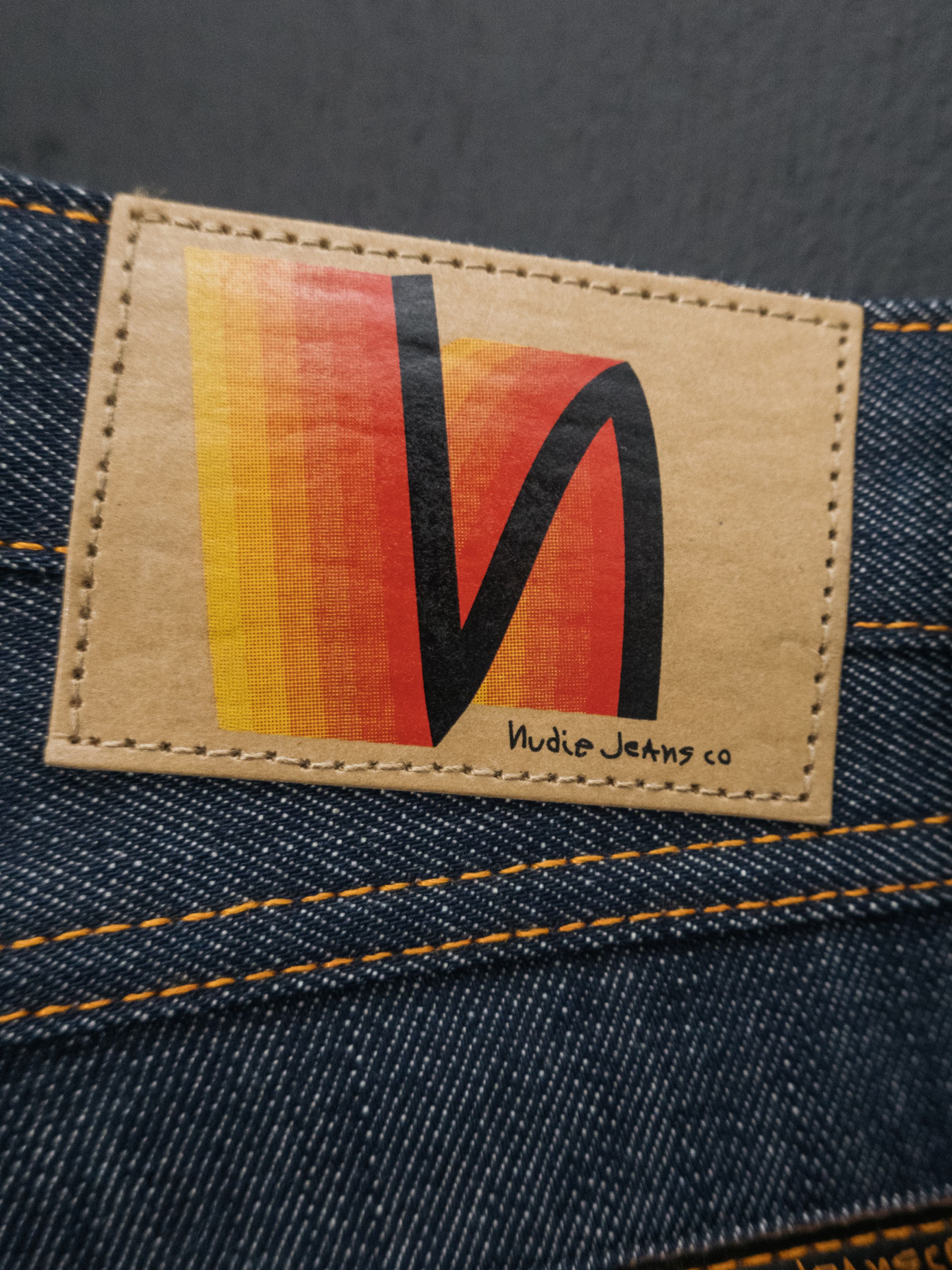 Nudie Jeans Wide Heidi Dry Sunburns, a detail shot of the jacron patch with a sunburns gradient design.