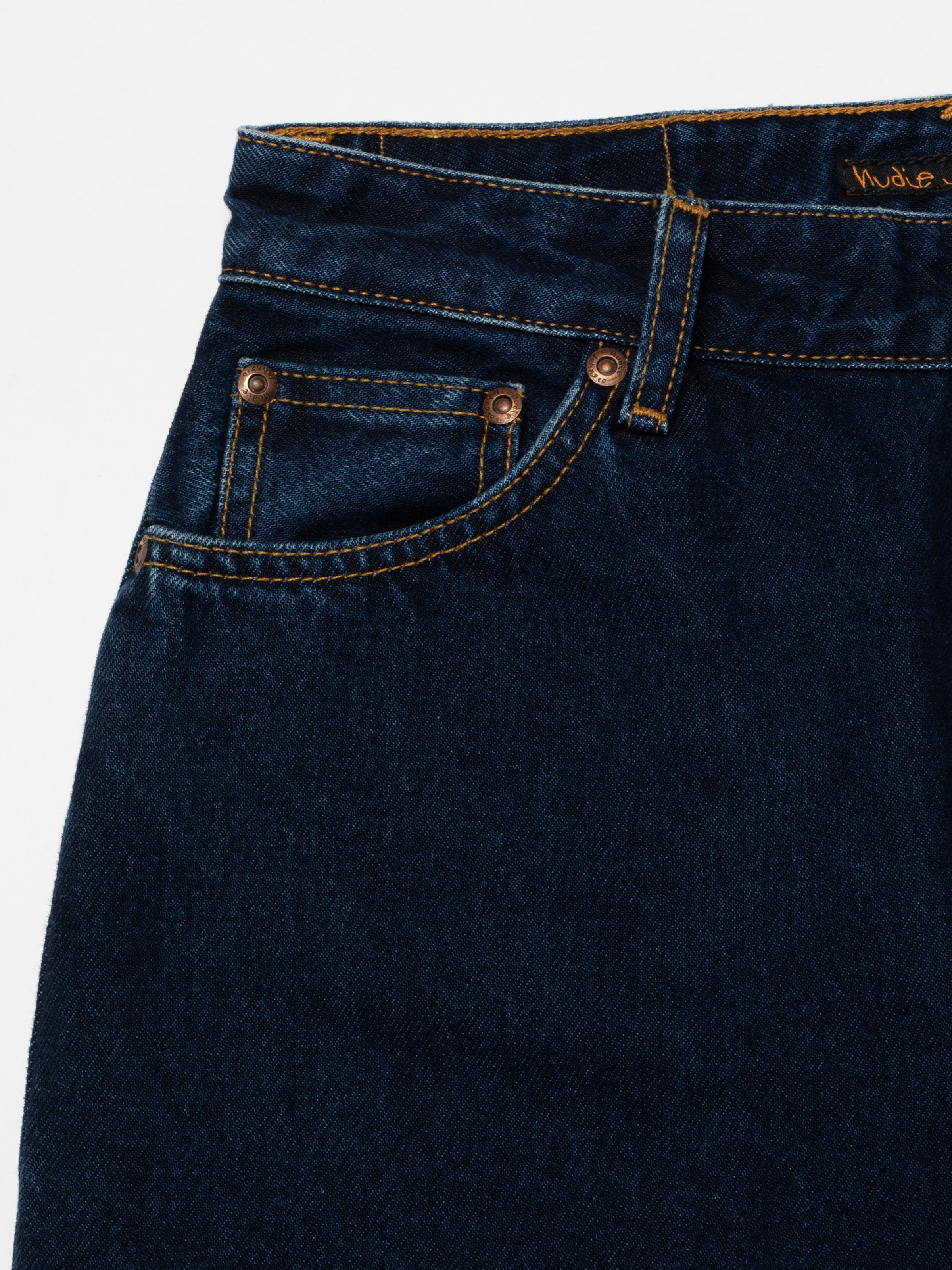 Nudie Jeans Lofty Lo in Indigo Dipped, Nahaufnahme der Damenjeans mit Bund, Münztasche und tabakfarbenen Nähten.
