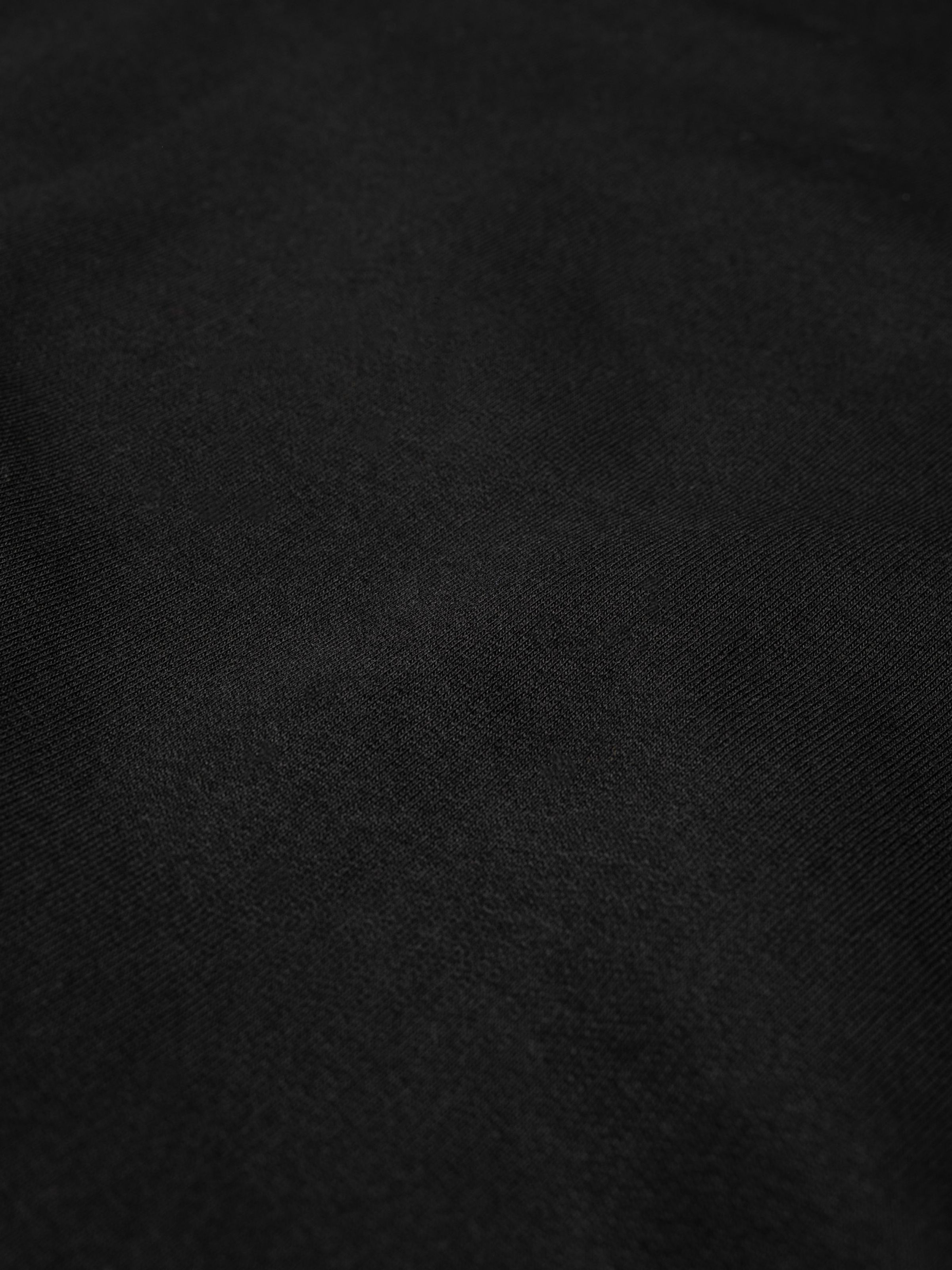 Nudie Jeans Palle Logo Sweatshirt in Black, a close-up shot of the black organic cotton jersey fabric.