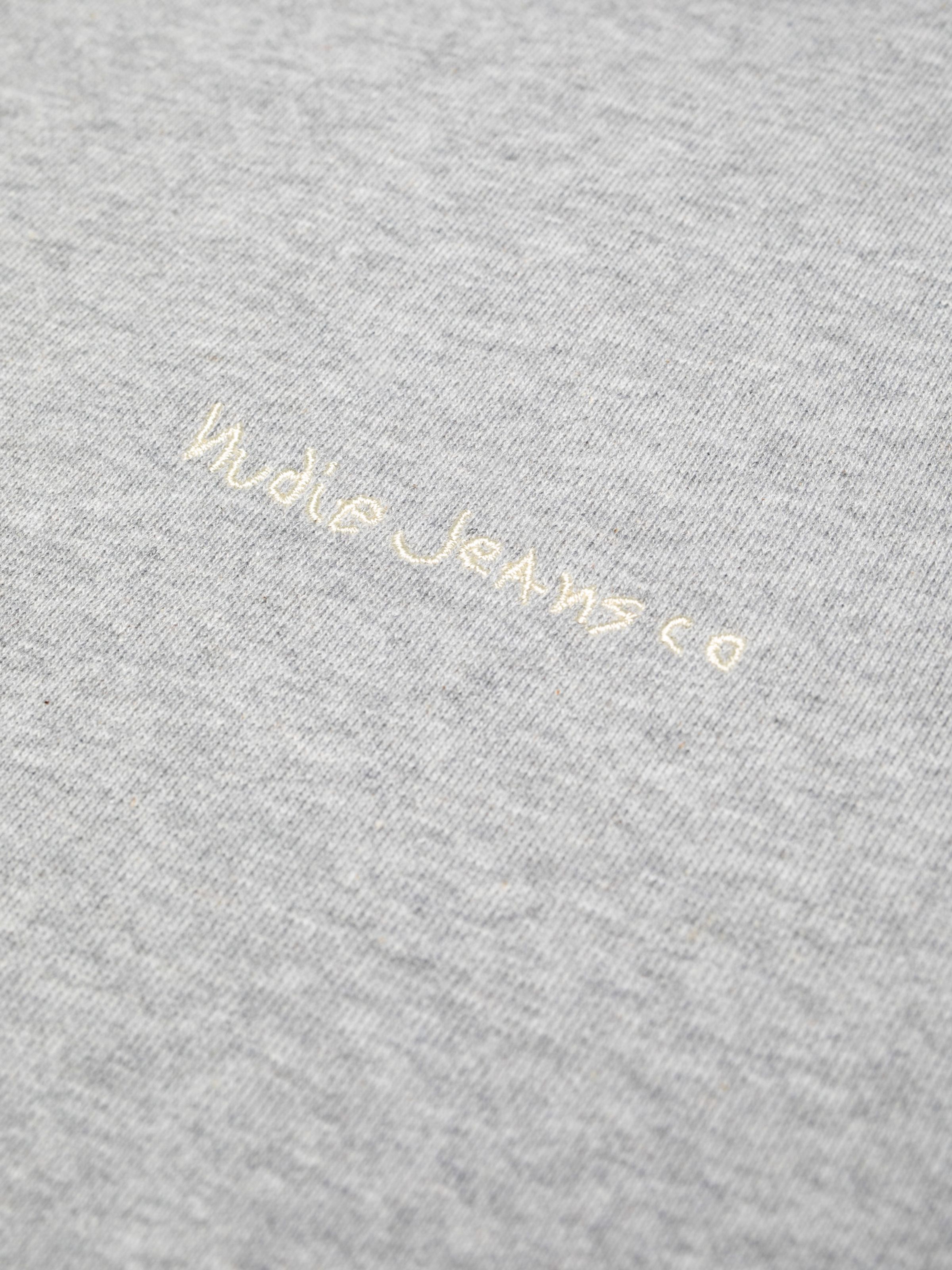 Nudie Jeans Palle Logo Sweatshirt in Greymelange, close-up showing the logo embroidery on the chest.