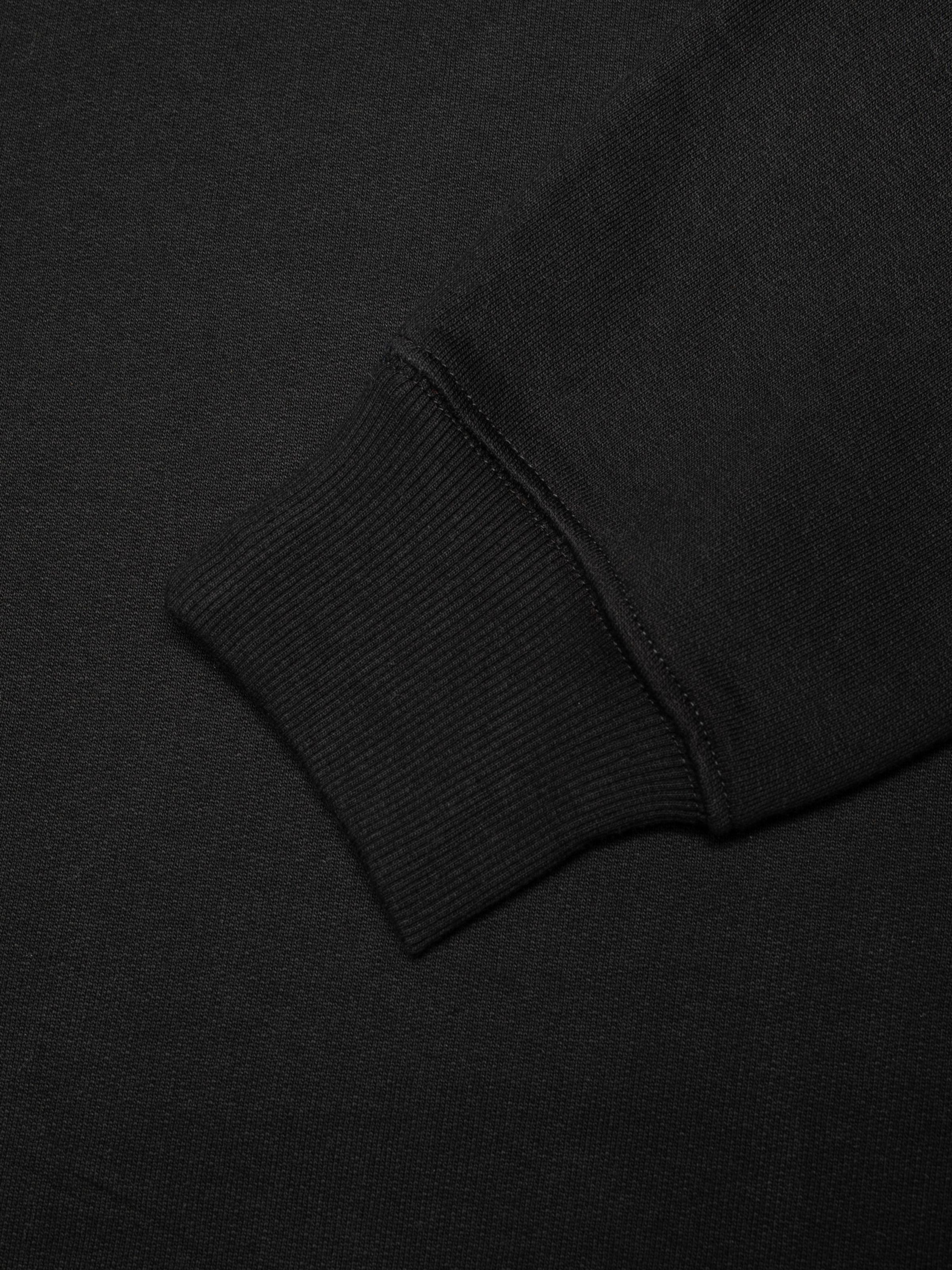 Nudie Jeans Palle Logo Sweatshirt in Black, a close-up detail shot of the sleeve's ribbed cuff.