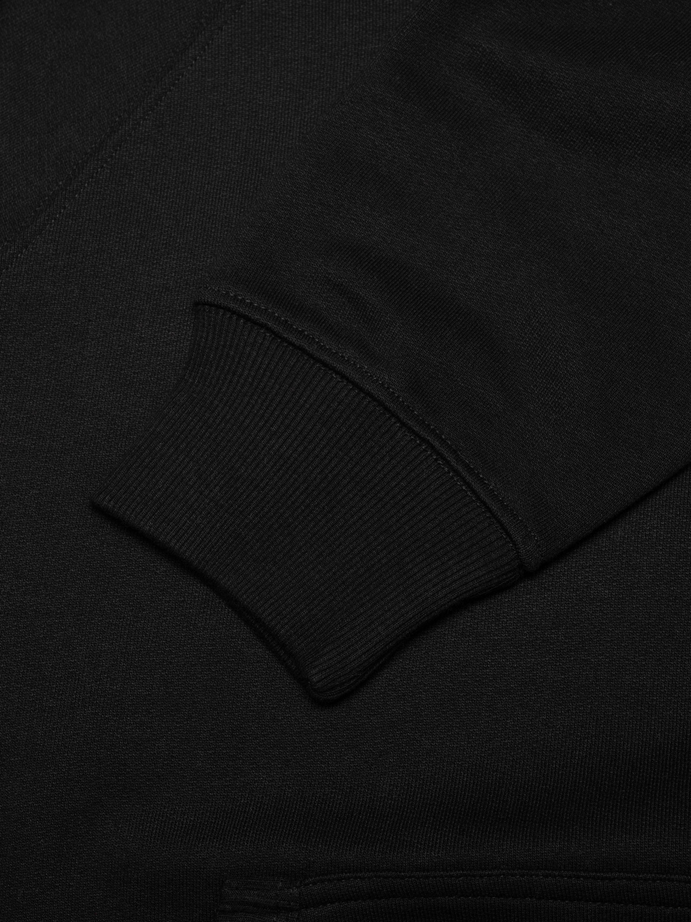 Nudie Jeans Gunde Logo Hoodie in Black, a close-up view showing the rib-knit cuff on the sleeve.