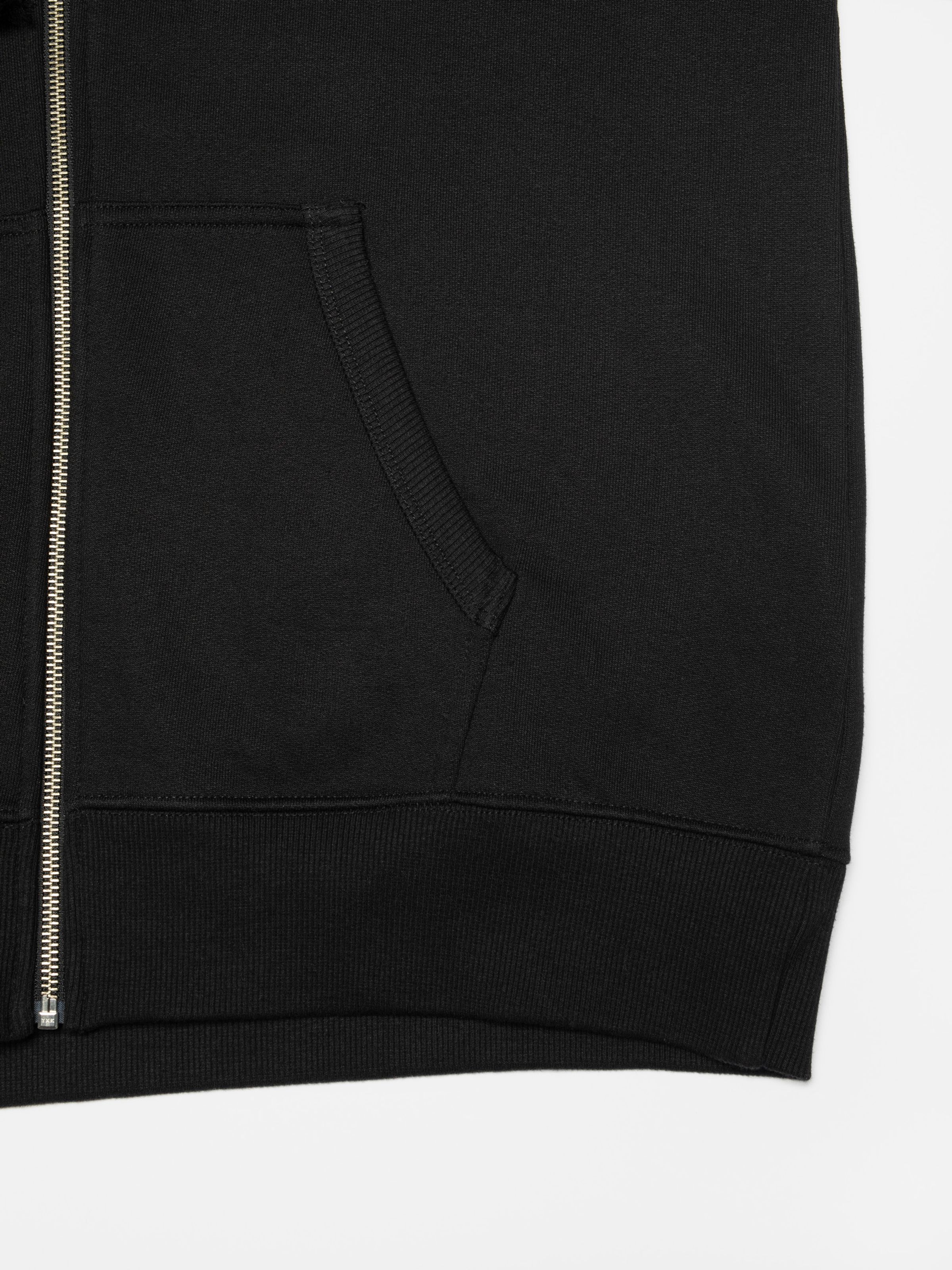 Nudie Jeans Gunde Logo Zip Hoodie in Black, a close-up showing the kangaroo pocket, zipper, and ribbed hem.