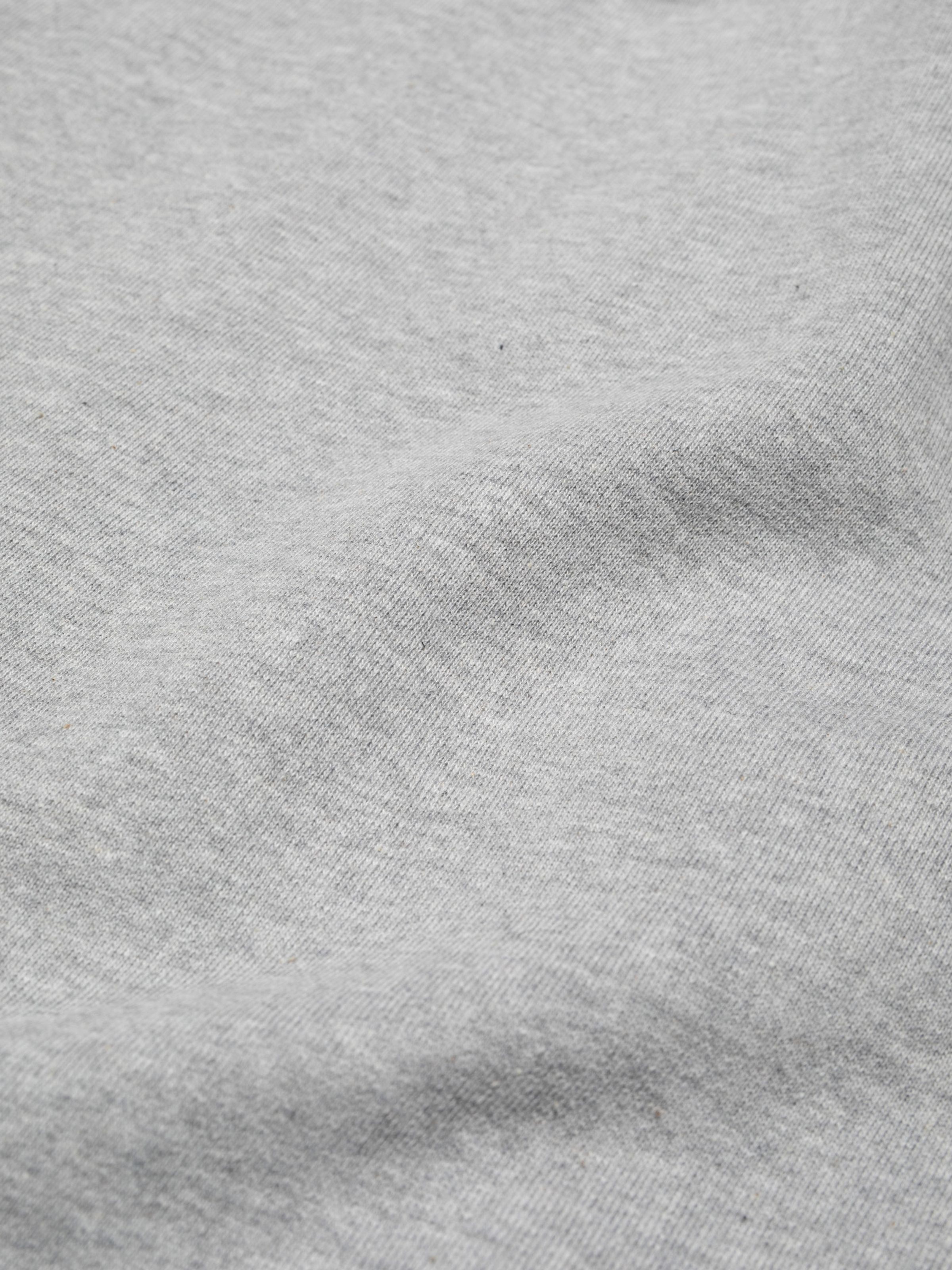 Nudie Jeans Gunde Logo Zip Hoodie in Greymelange, a close-up shot showing the texture of the organic cotton jersey.