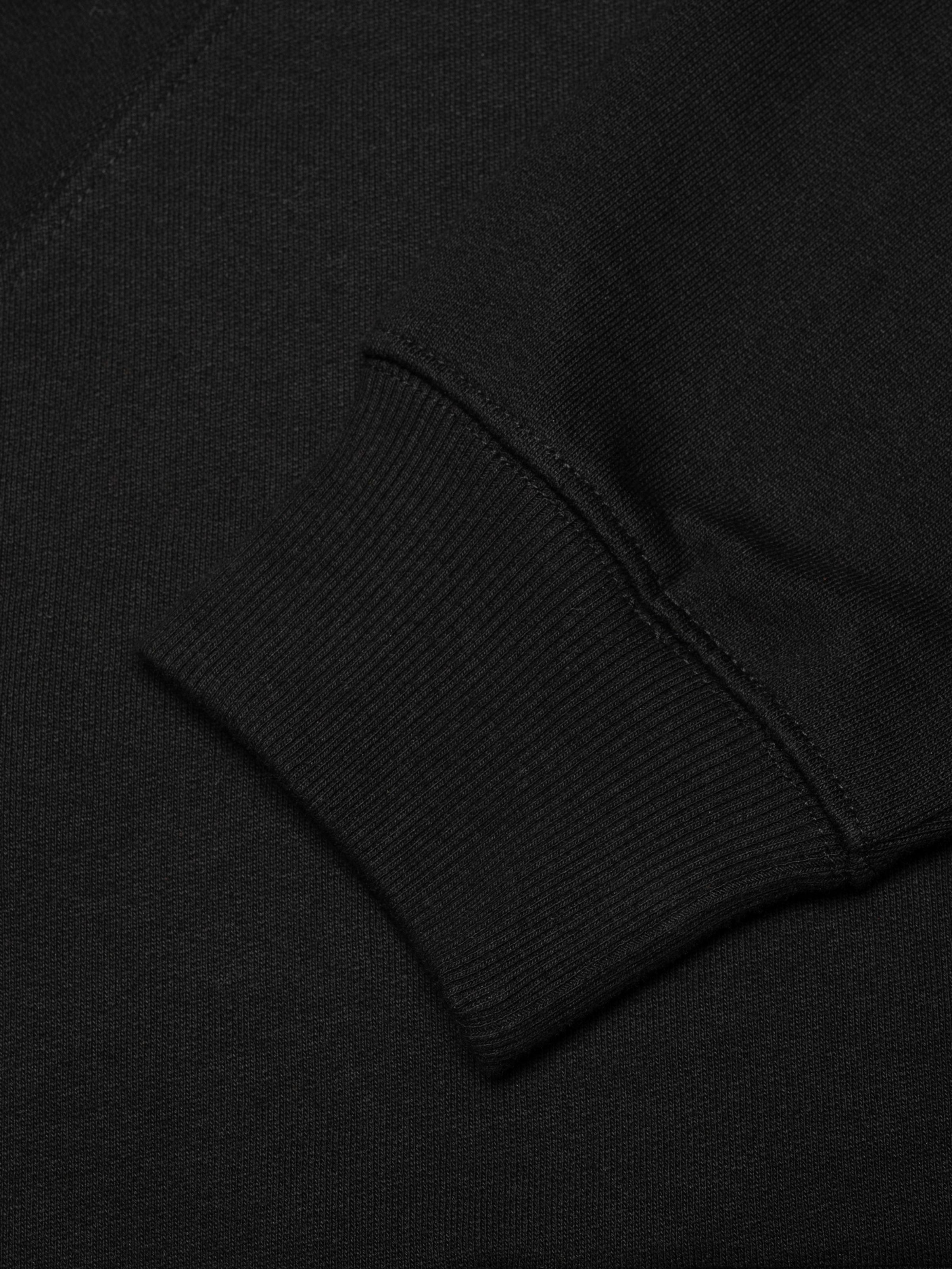 Nudie Jeans Gunde Logo Zip Hoodie in Black, a close-up shot of the ribbed sleeve cuff.
