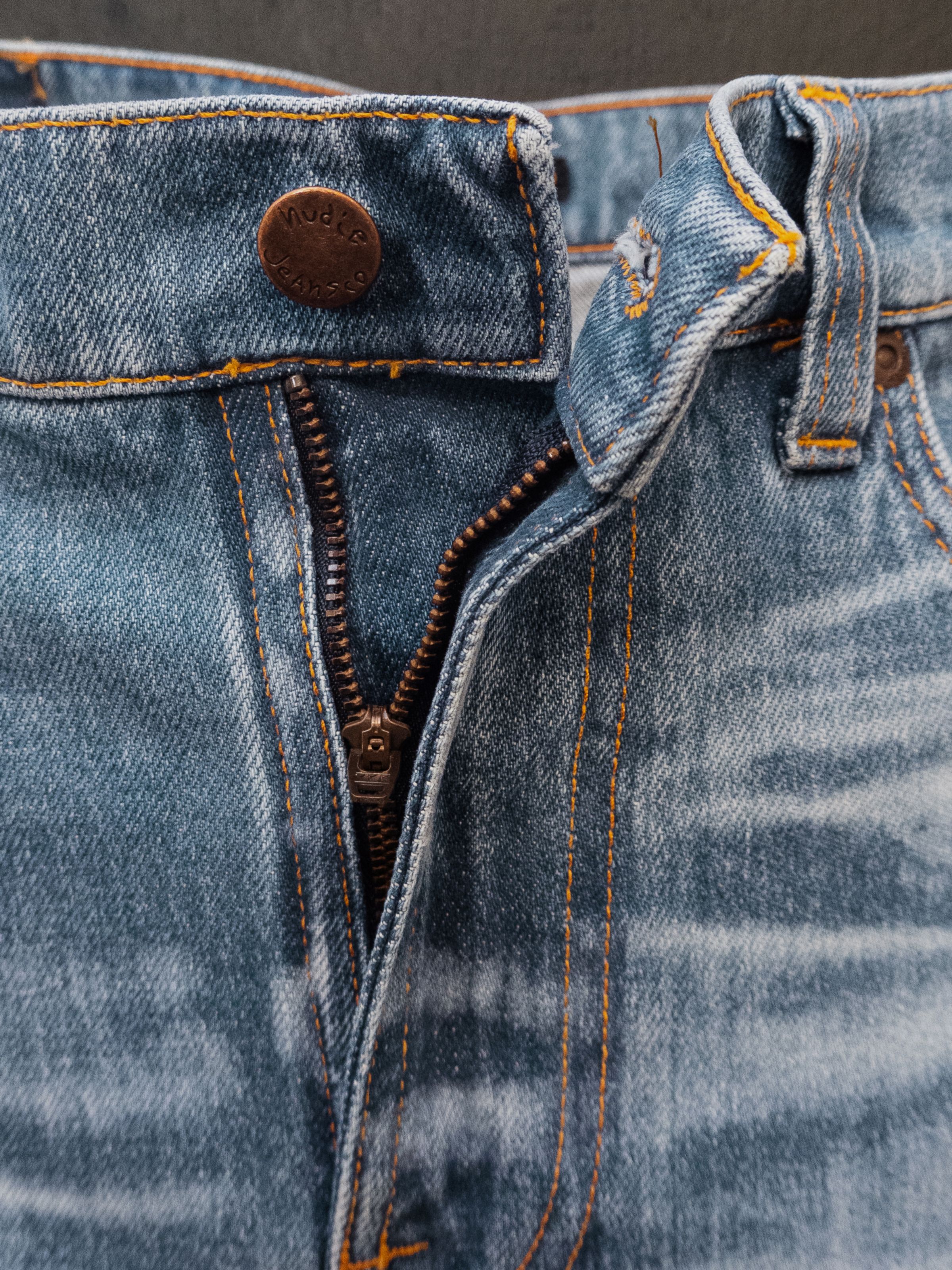 Nudie Jeans Lean Dean Hidden Tracks, close-up of the zip fly, showing the copper hardware and signature orange stitching.
