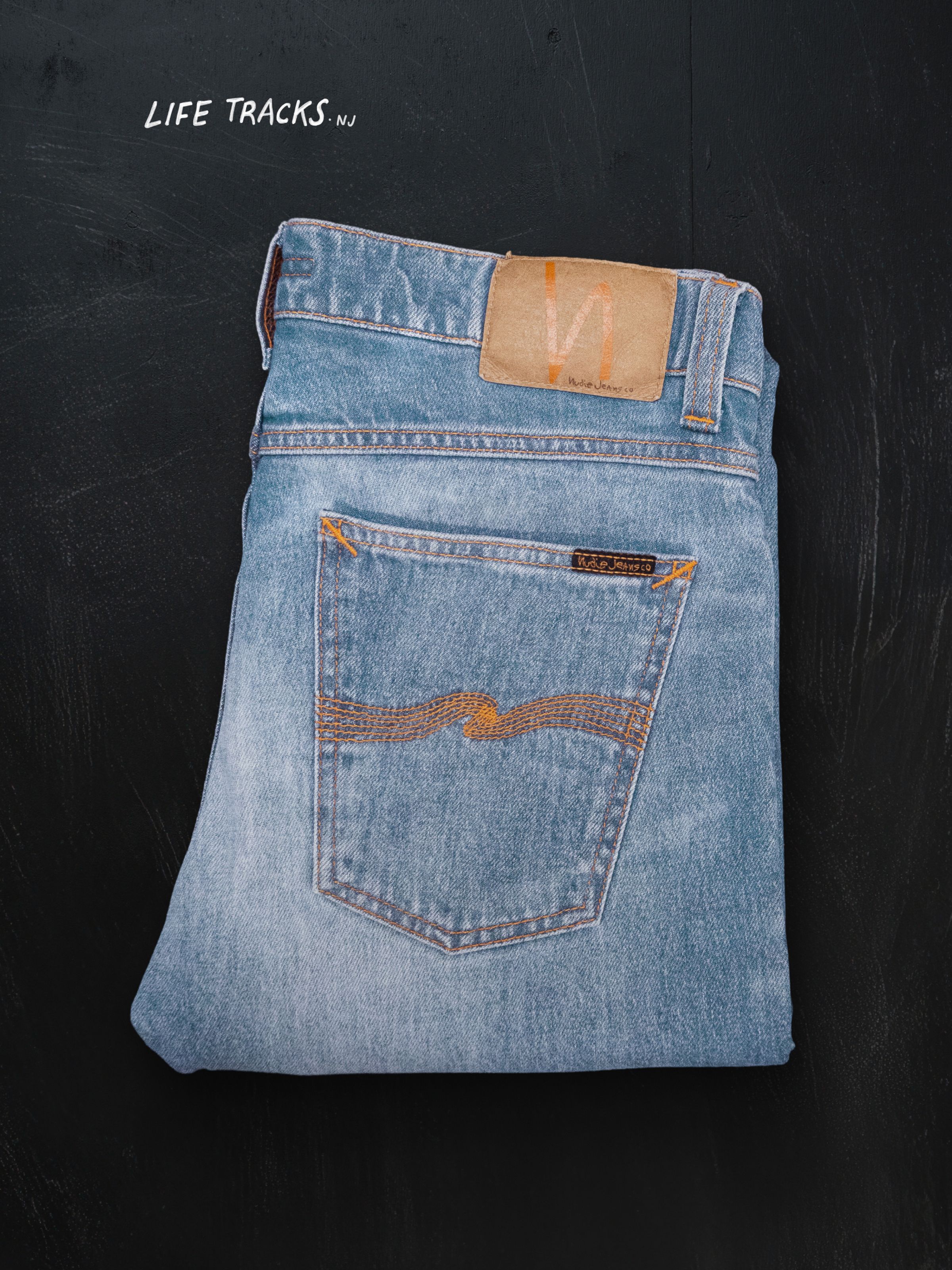Nudie Jeans Lean Dean in Hidden Tracks, men's slim fit jeans shown folded against a black background.