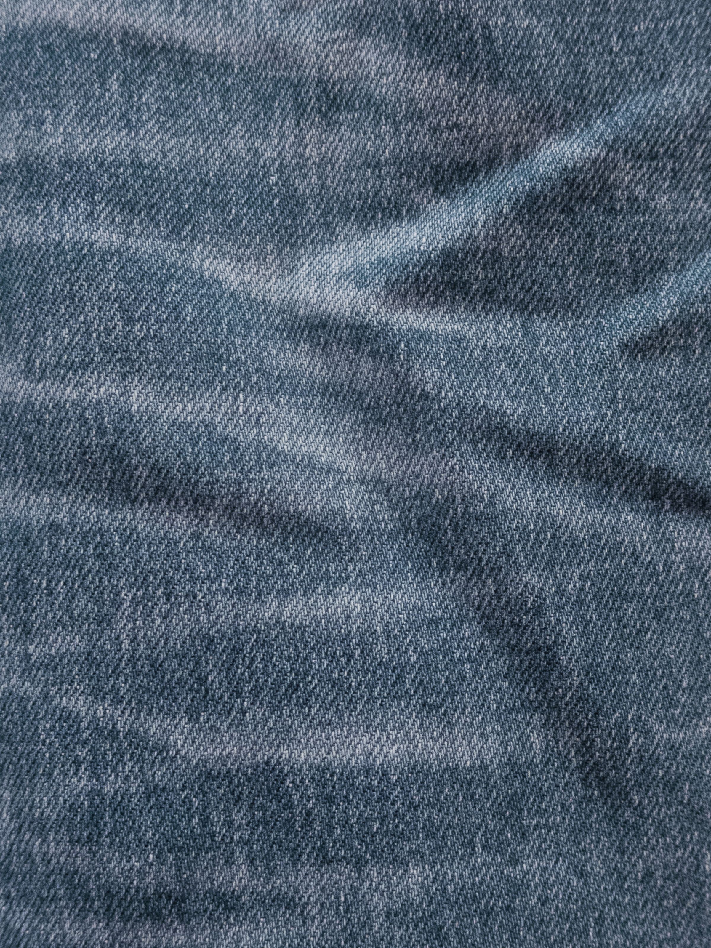 Nudie Jeans Lean Dean Hidden Tracks, close-up of the light blue wash showing authentic wear marks and slubby denim texture.