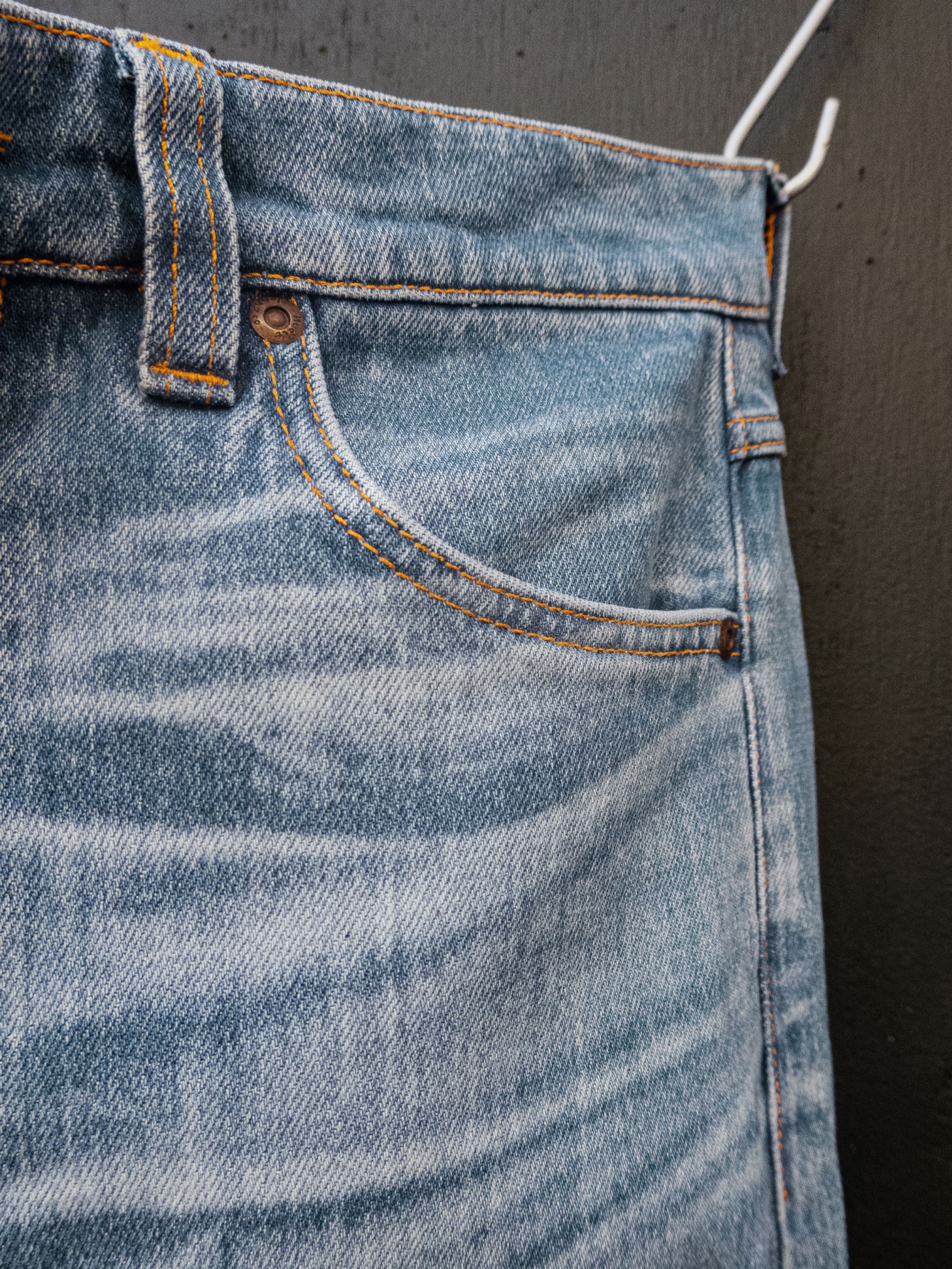 Nudie Jeans Lean Dean Hidden Tracks, close-up of the front pocket's authentic fades on light blue stretch denim.